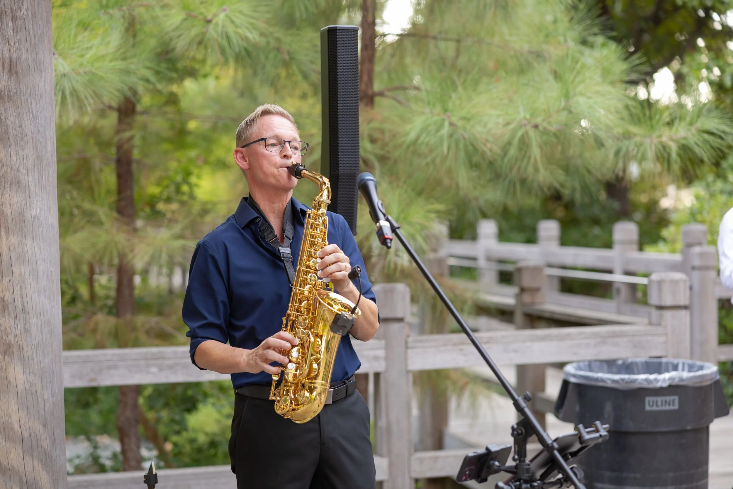 Live saxophonist performing during an outdoor wedding ceremony at the Fort Worth Botanic Garden