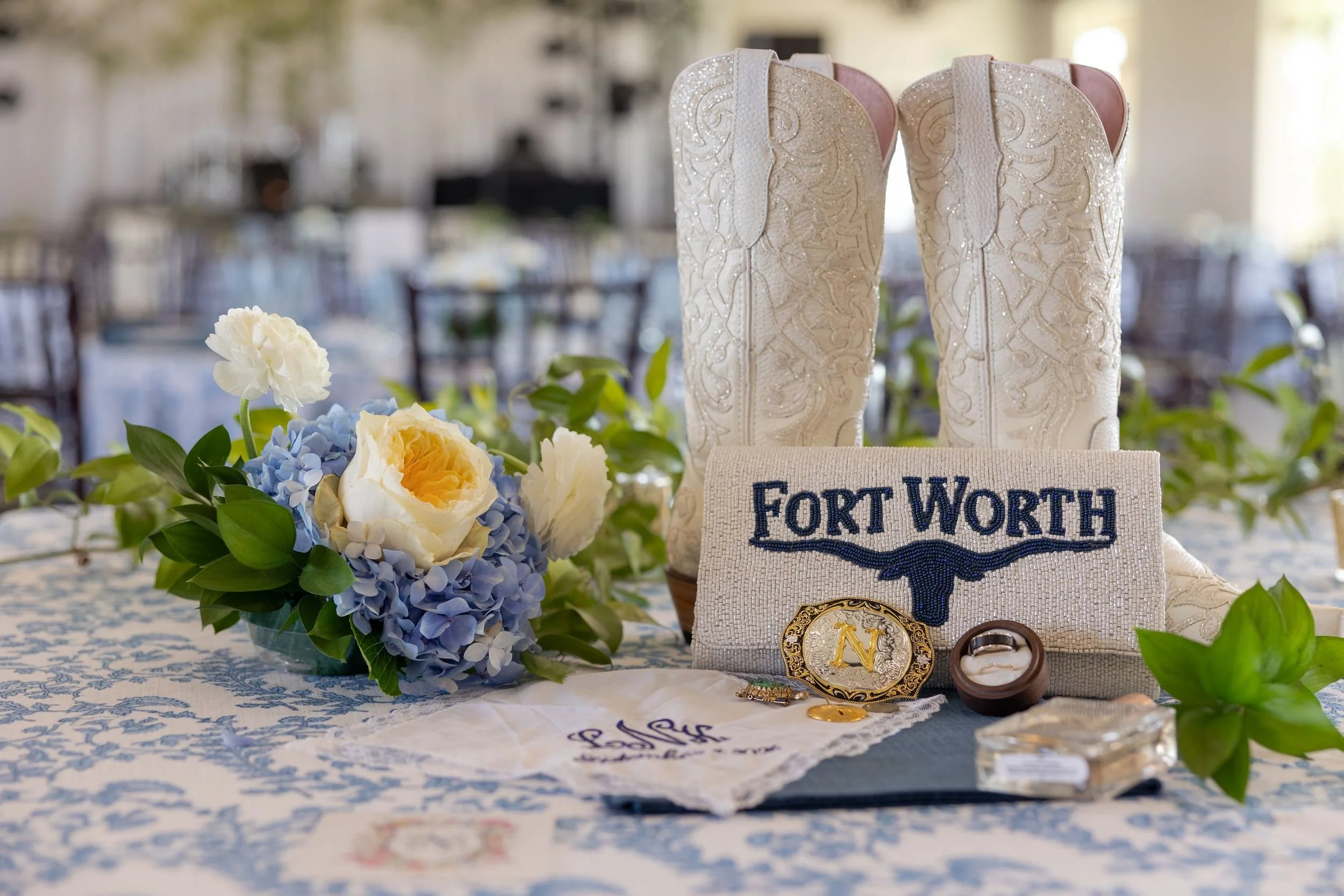 Blue and white floral centerpiece with a Fort Worth sign at Lacey and Jason's reception