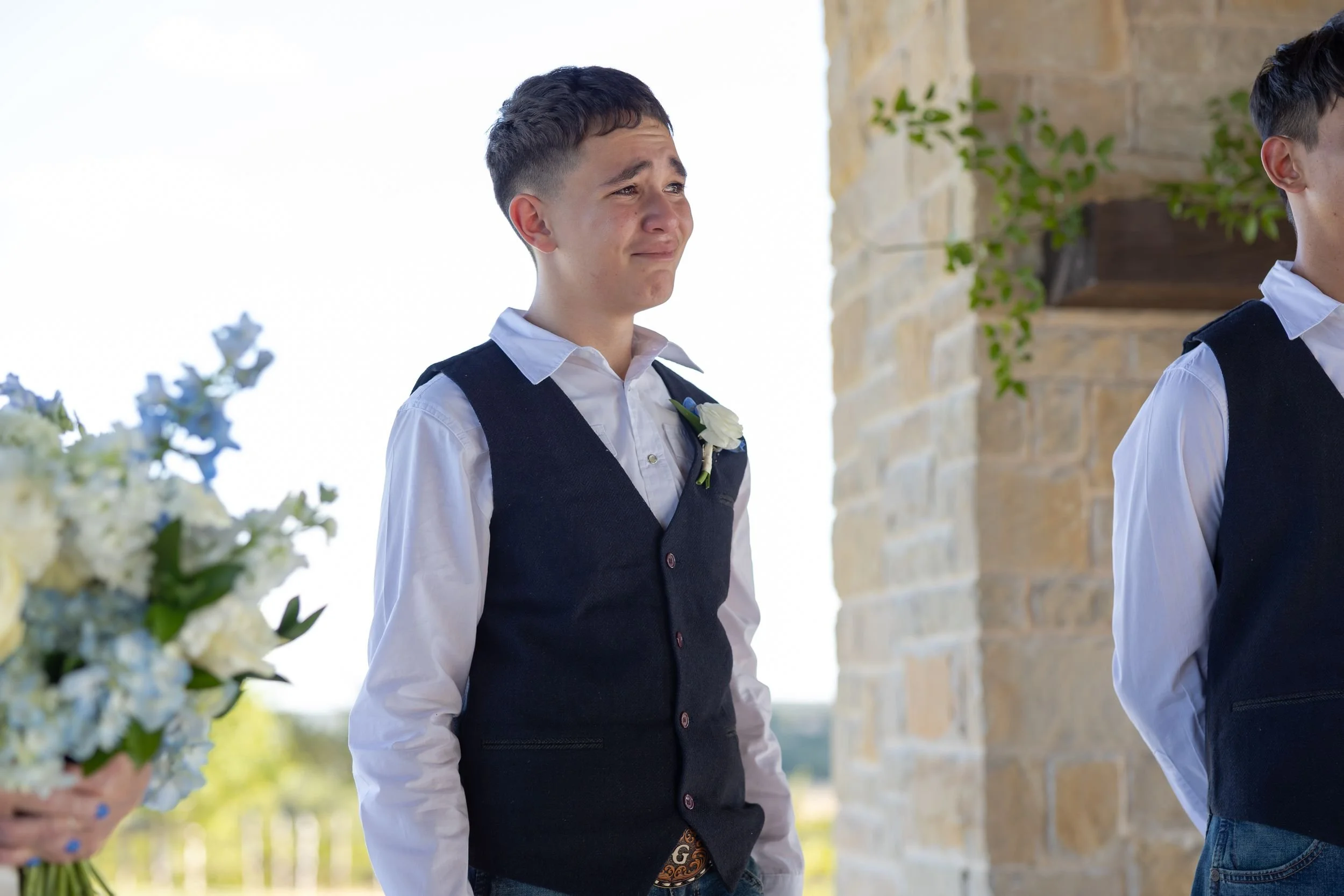 Groomsman in a navy vest watching the ceremony at Dove Ridge Vineyard