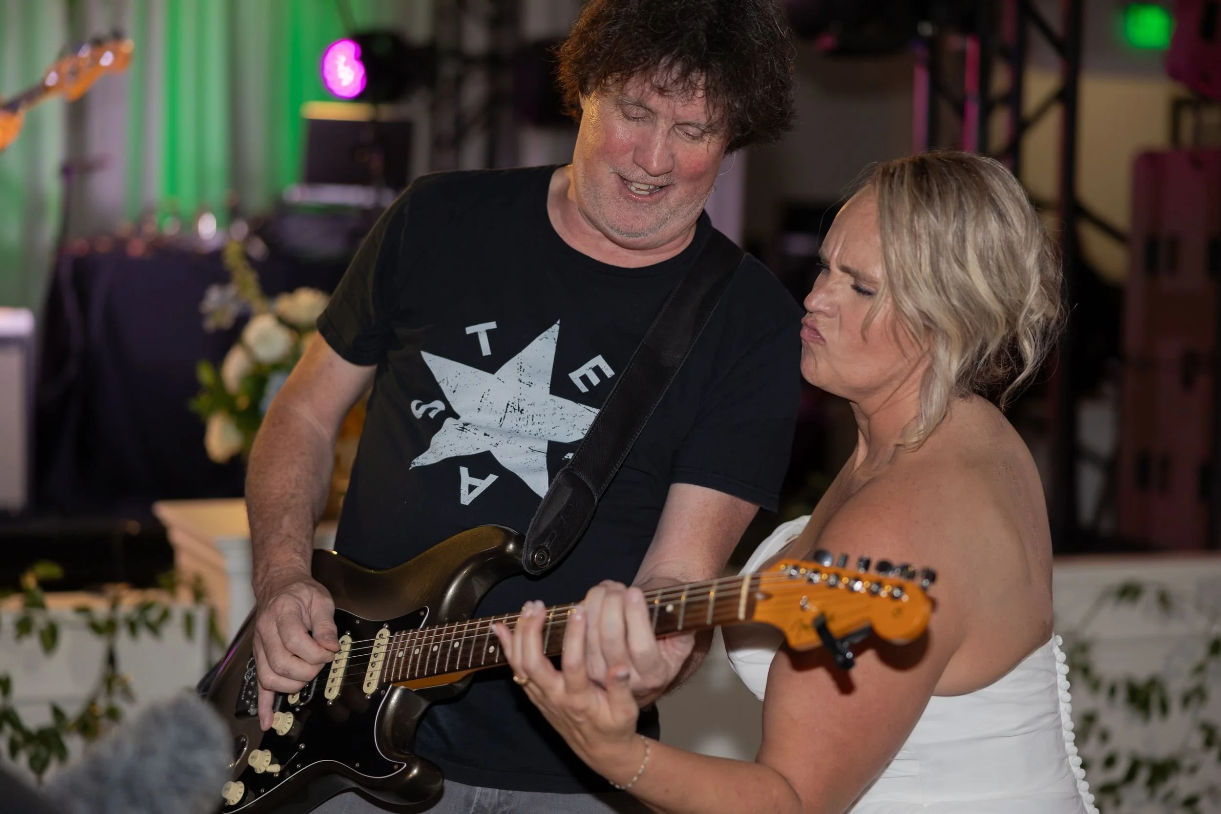 Bride posing with the band's guitarist at her Dove Ridge Vineyard reception