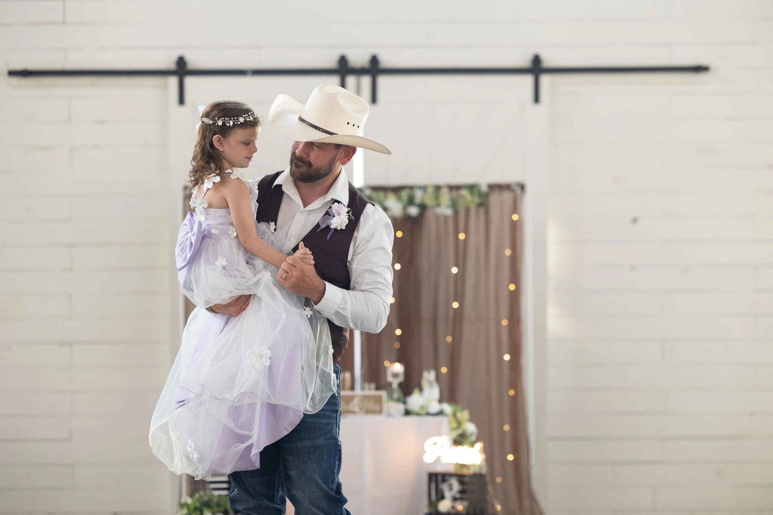 Bride and groom dancing in front of sliding barn doors at their Weatherford reception