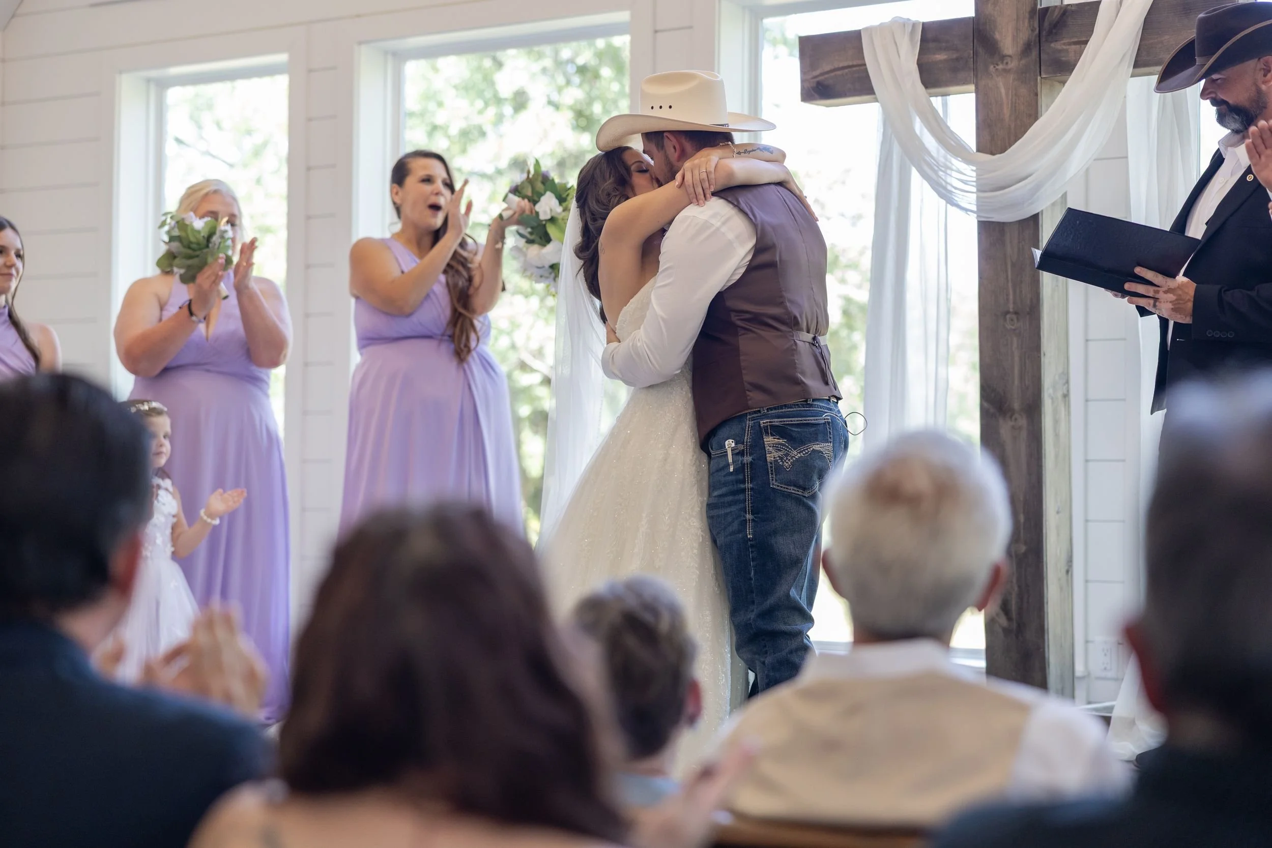 Bride and groom exchanging vows at the altar of a white chapel in Weatherford, Texas