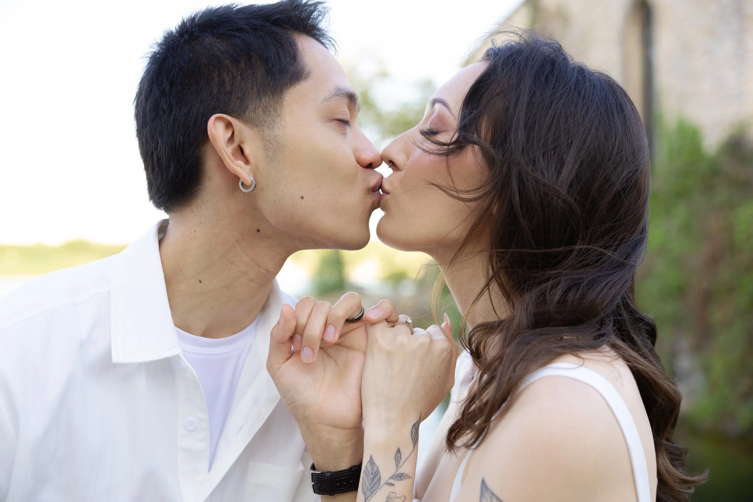Engaged couple kissing and holding hands during a Fort Worth engagement session