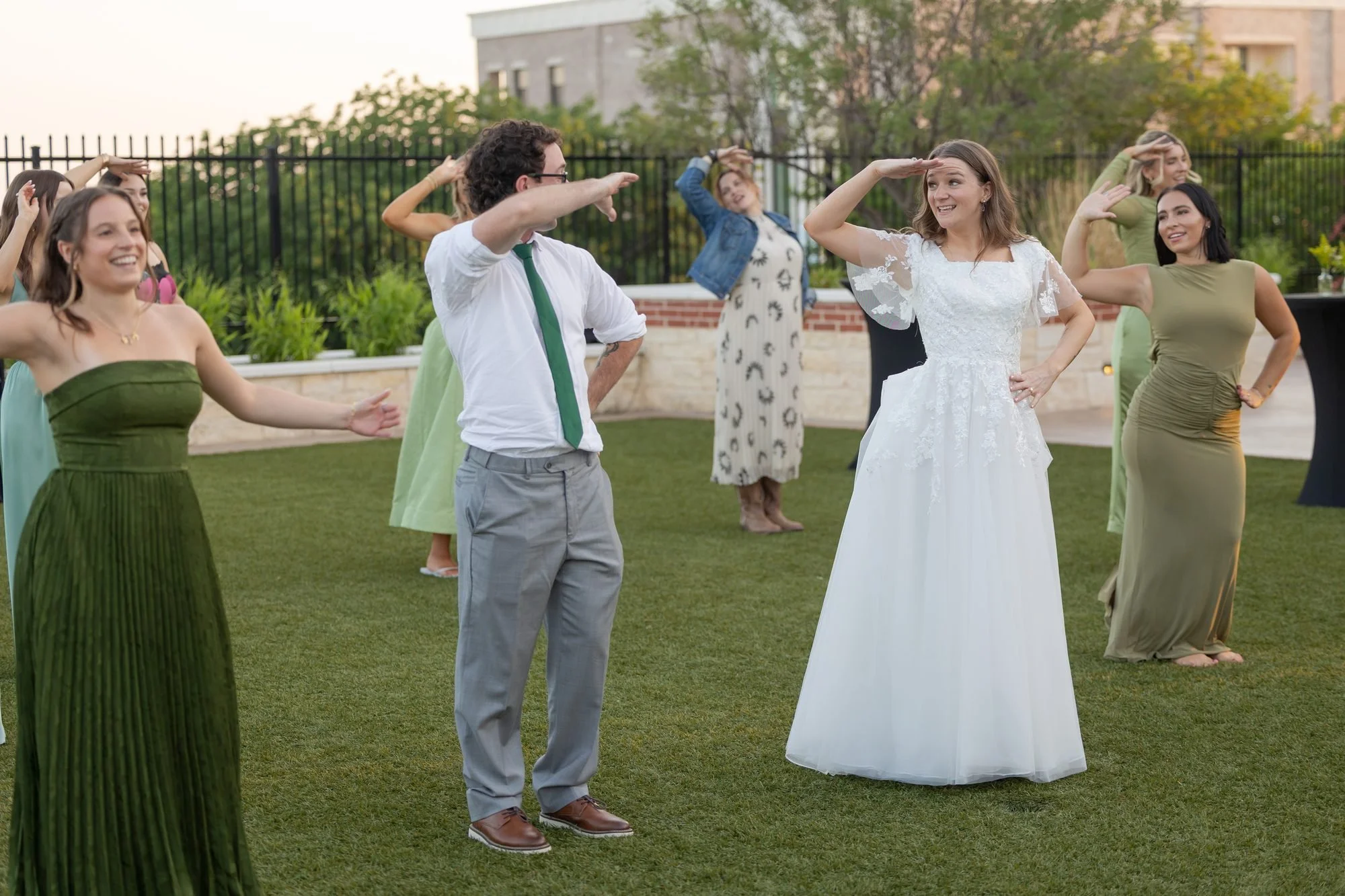 Bride and guests line dancing on the lawn at an outdoor DFW wedding reception