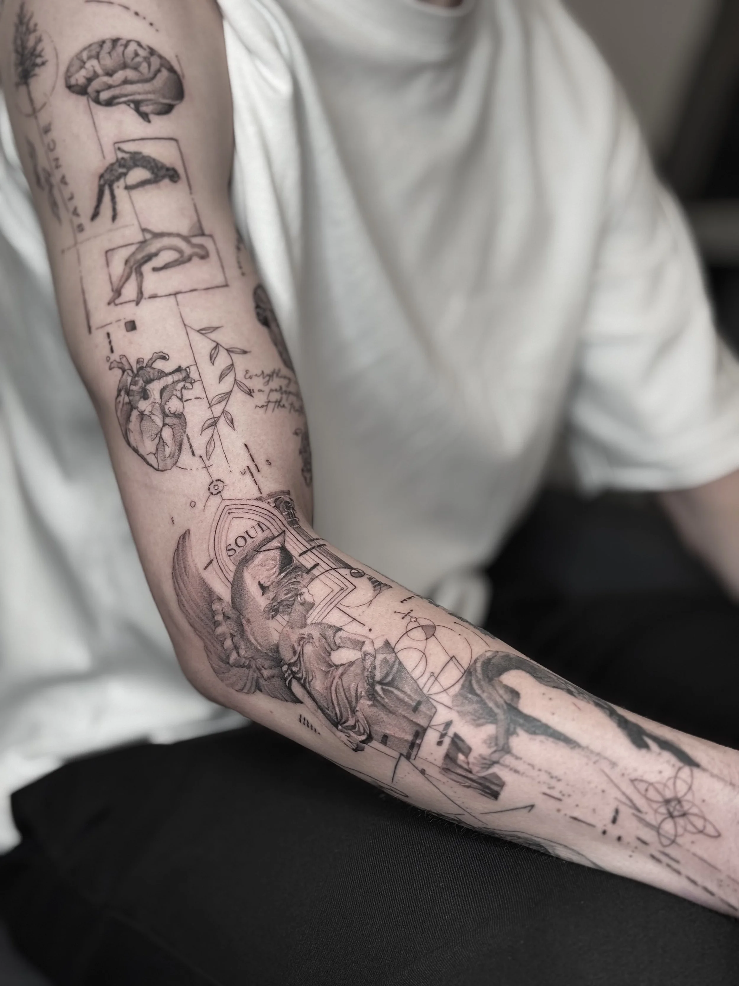 Tattoo sleeve featuring anatomical drawings, botanical elements, and abstract geometric designs. Explore micro-realism tattoos at NEXT in Paris. From animals to meaningful objects, discover detailed designs created on a small scale.