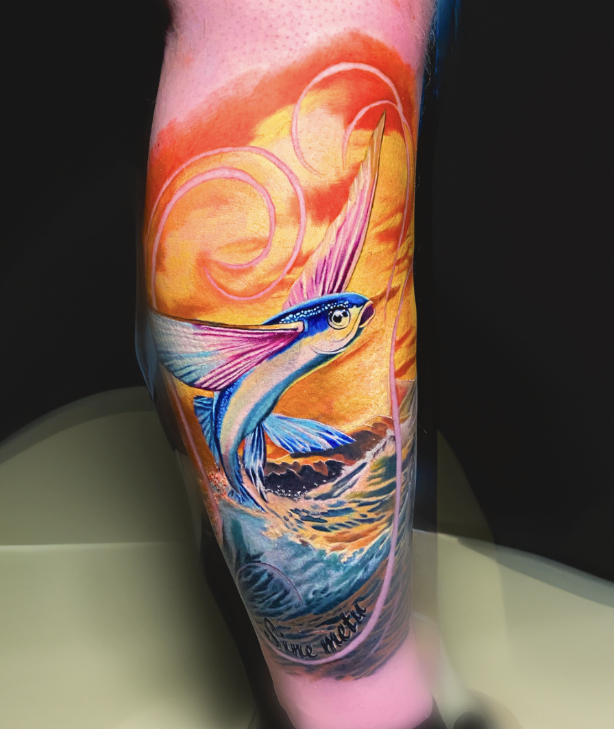 A colorful tattoo of a hummingbird flying over a body of water with a sunset in the background. Cover-up tattoo in Paris.