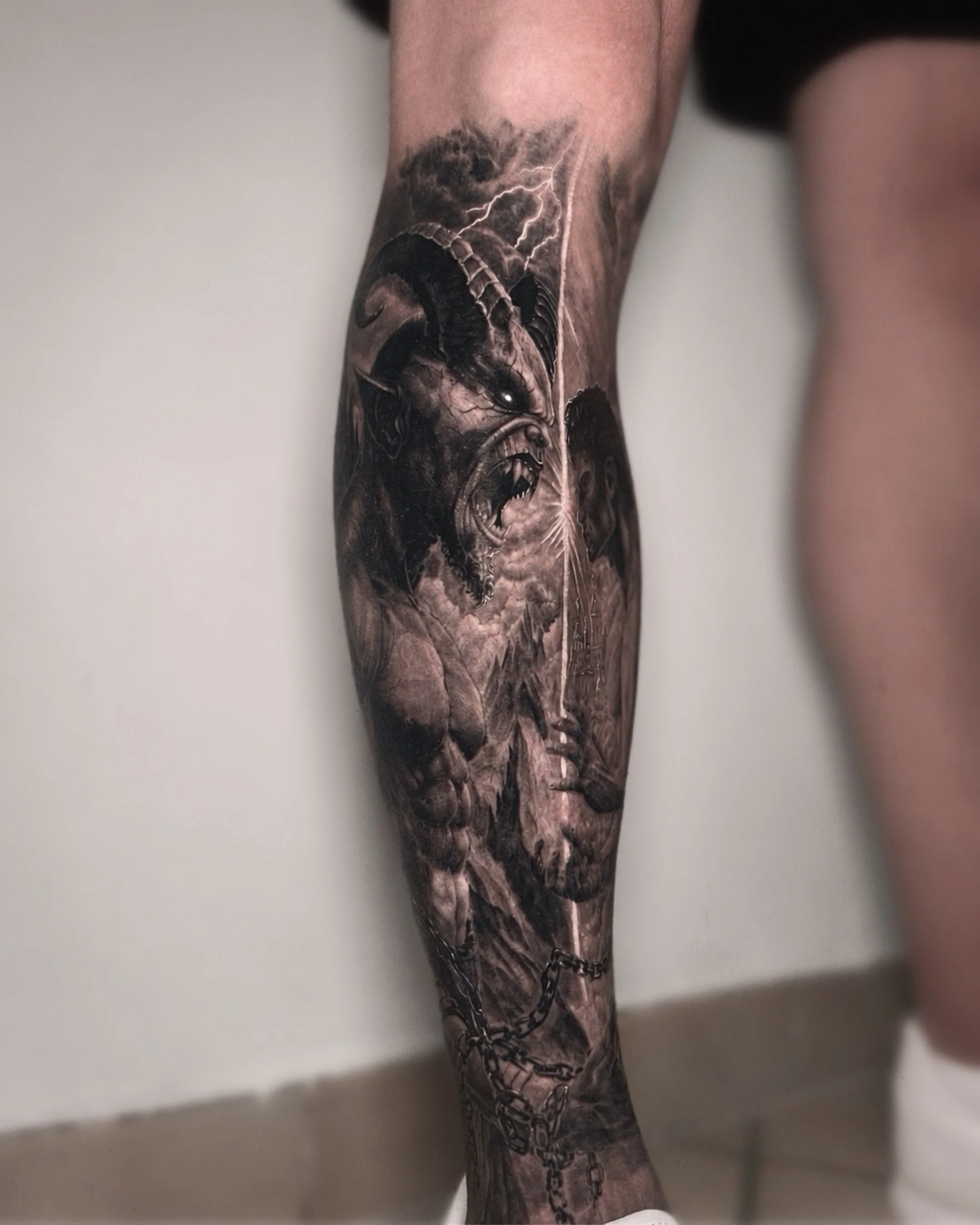 Tattoo sleeve of a fierce dog adorned with chains and lightning, covering the person's lower arm.