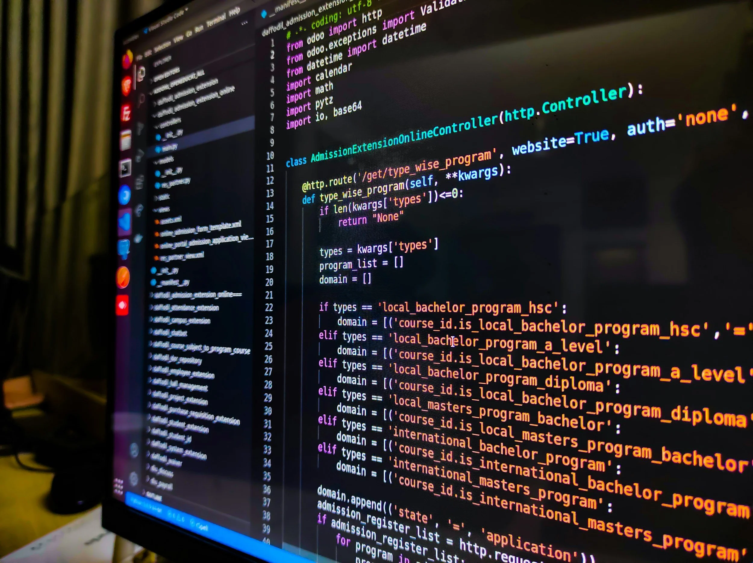 Close-up of a computer screen displaying colorful lines of Python programming code, with a dark background and a list of files on the left side.