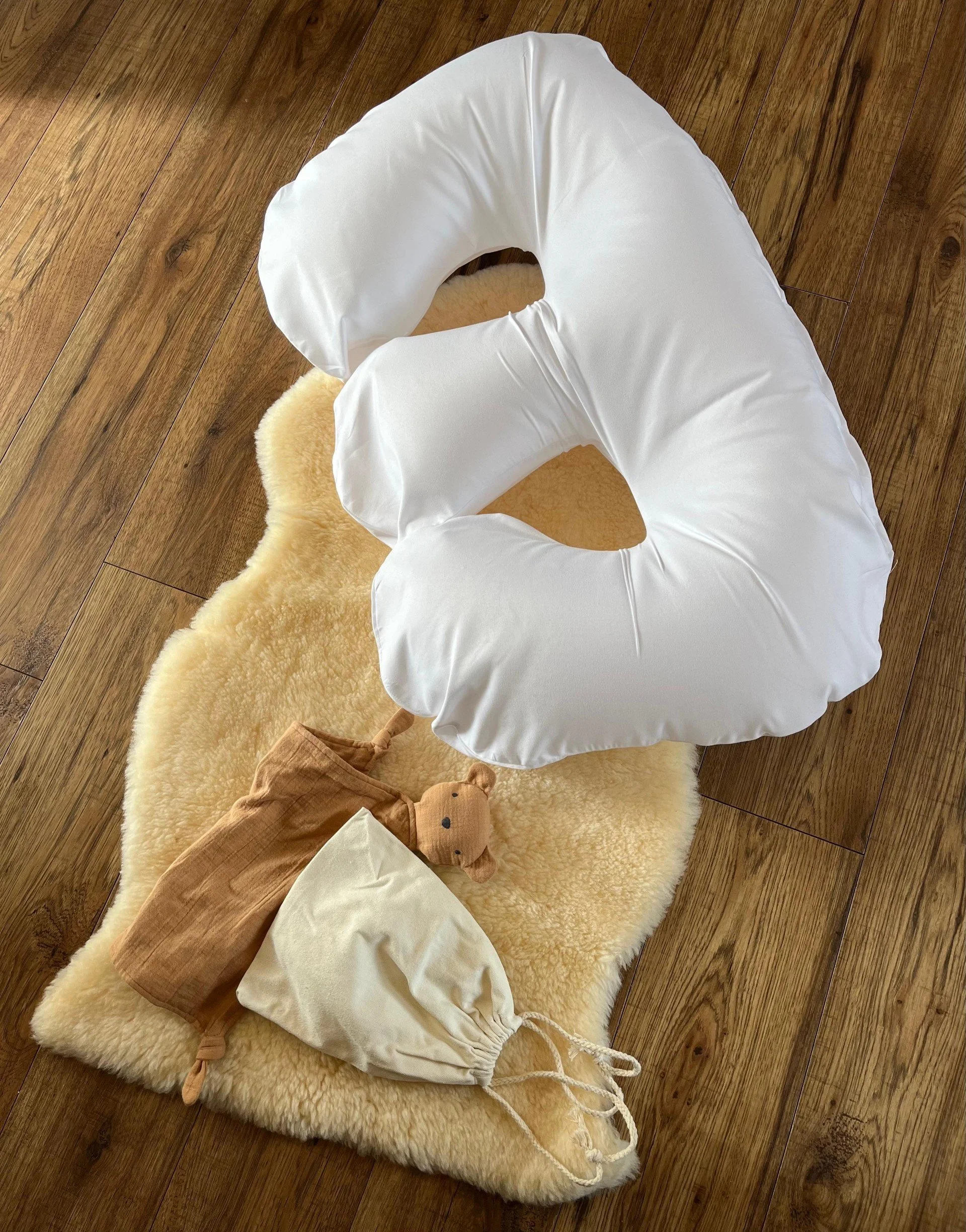 White twin support pillow concept displayed on a soft rug with a teddy bear.