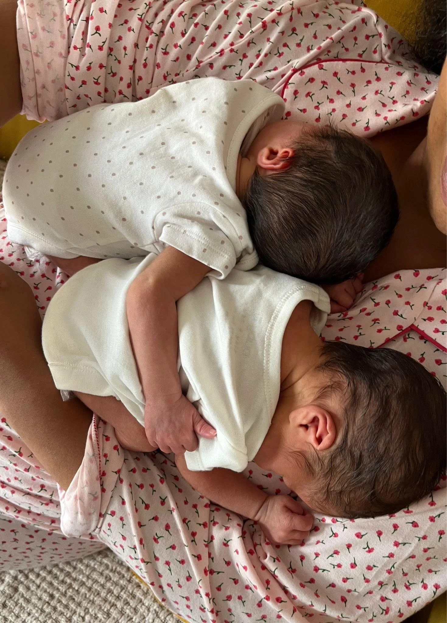 Newborn baby being gently held in an adult’s arms at home.