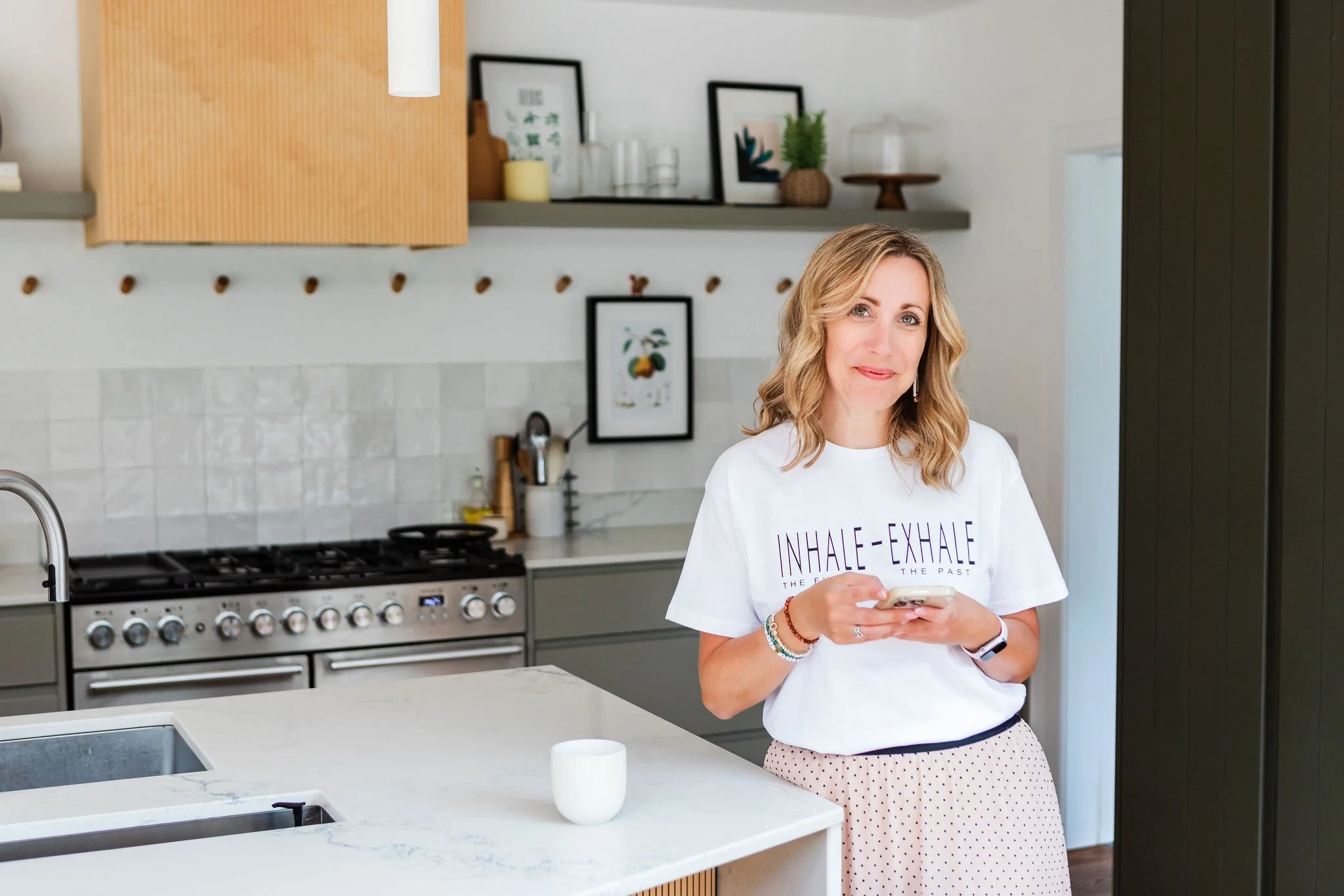 Lee-Anne Burgess standing in a kitchen looking at her phone.
