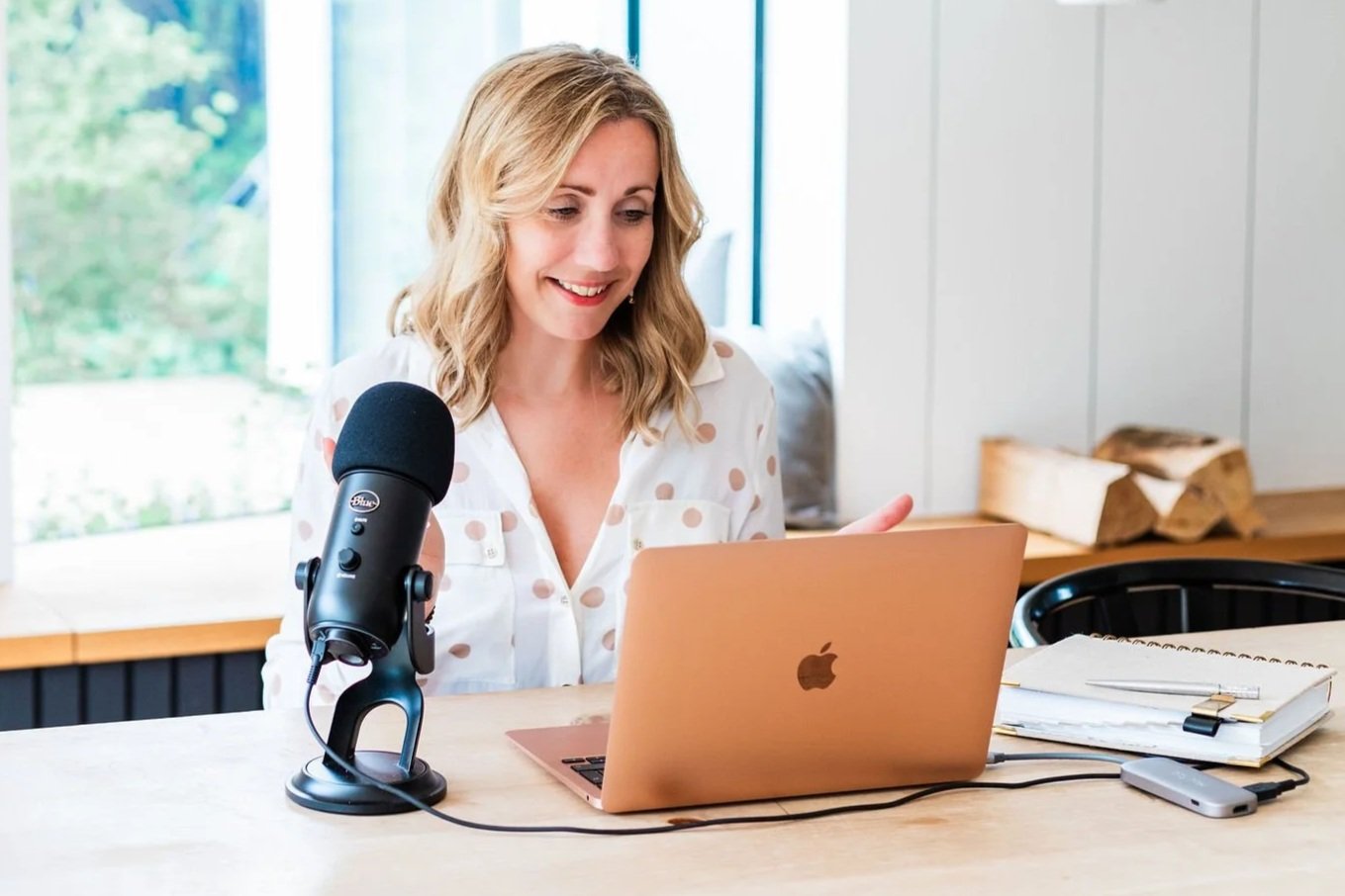 Lee-Anne Burgess working at her desk with a microphone beside her laptop.