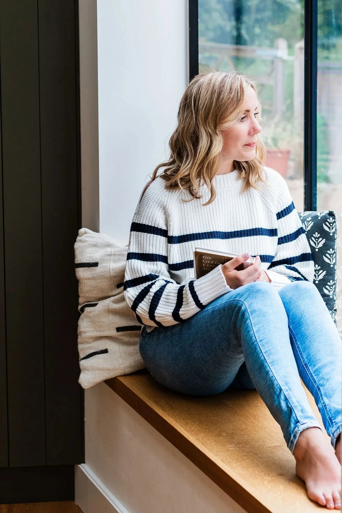 Lee-Anne Burgess sitting by a window with a book.