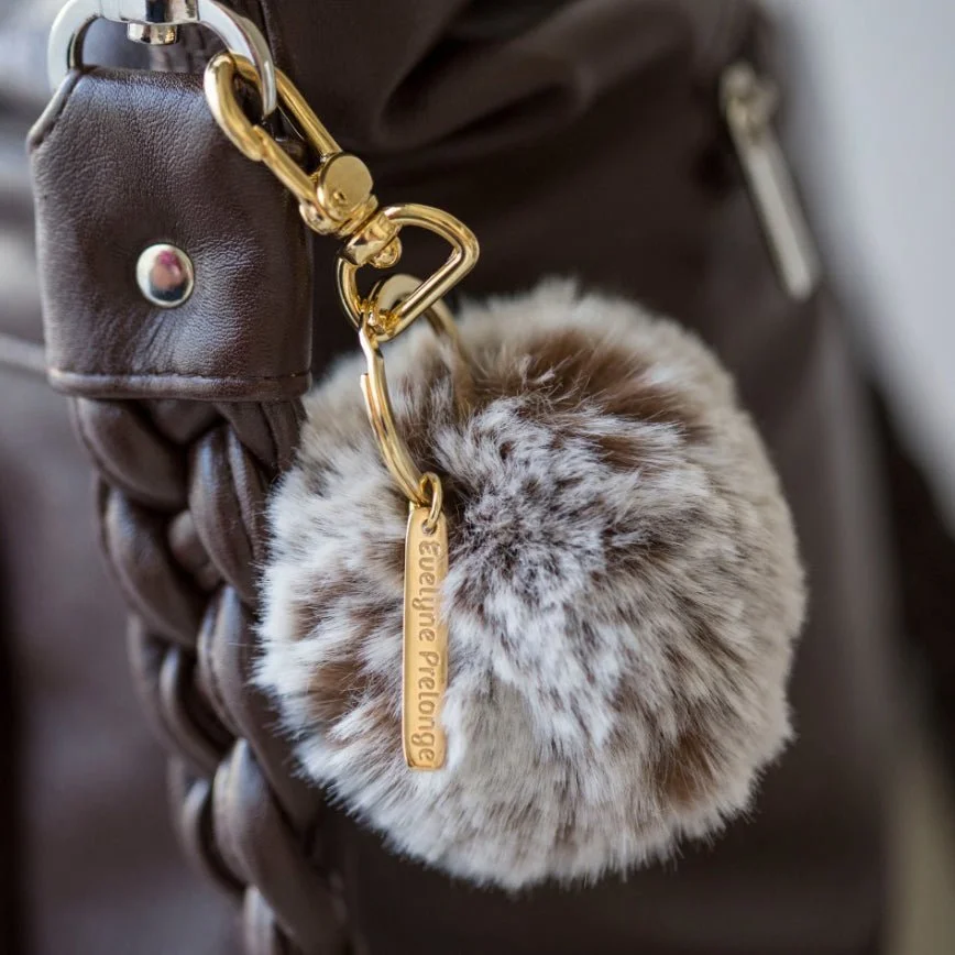 Evelyne Prélonge faux fur pompom key chain in chestnut on a leather bag