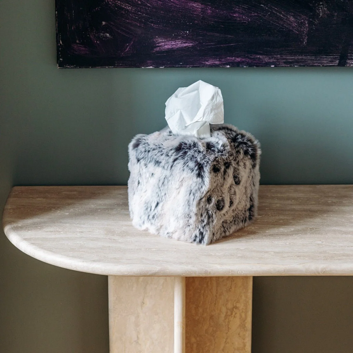 Square Glacier faux fur tissue box cover on a console against a dark wall