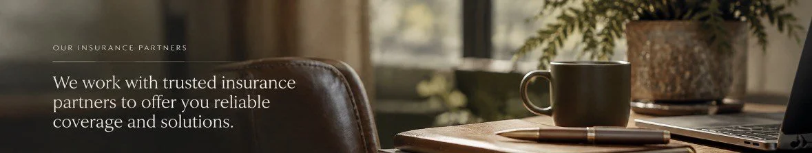 Part of an advertisement for insurance partners showing a workspace with a leather chair, a wooden desk with a coffee mug, a pen, a closed laptop, and a plant in the background.