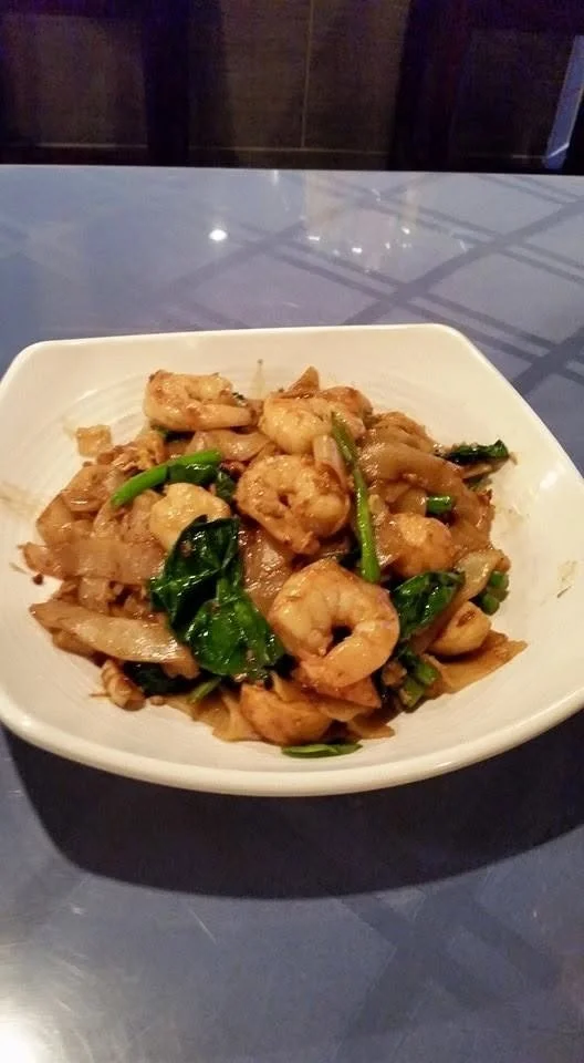 Stir-fried shrimp with vegetables served in a white square bowl