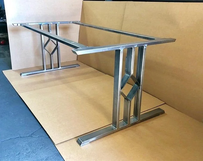 Unique metal desk frame on a wooden surface with a plain background.