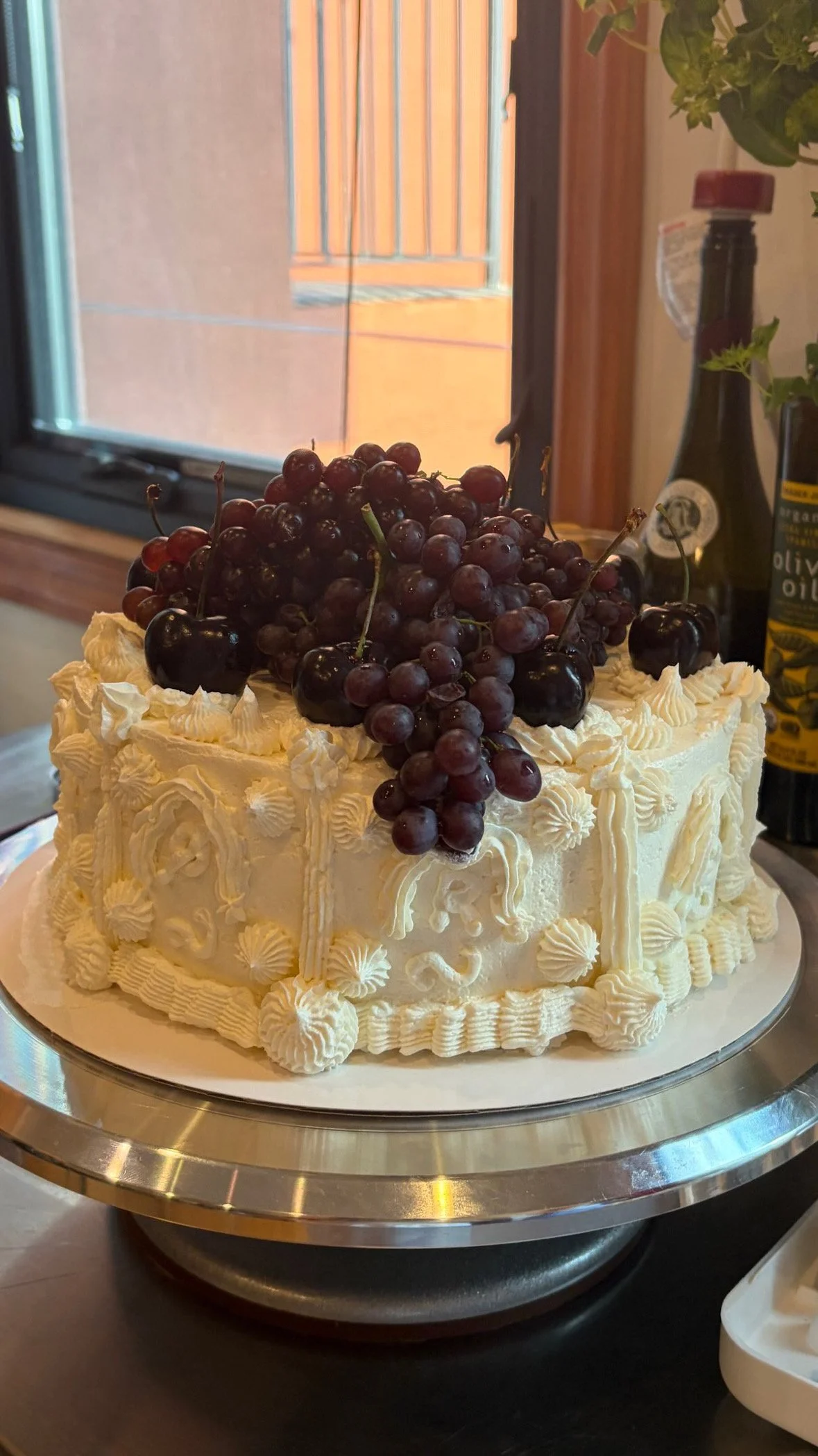 romantic white piped cake with cherries and champagne grapes