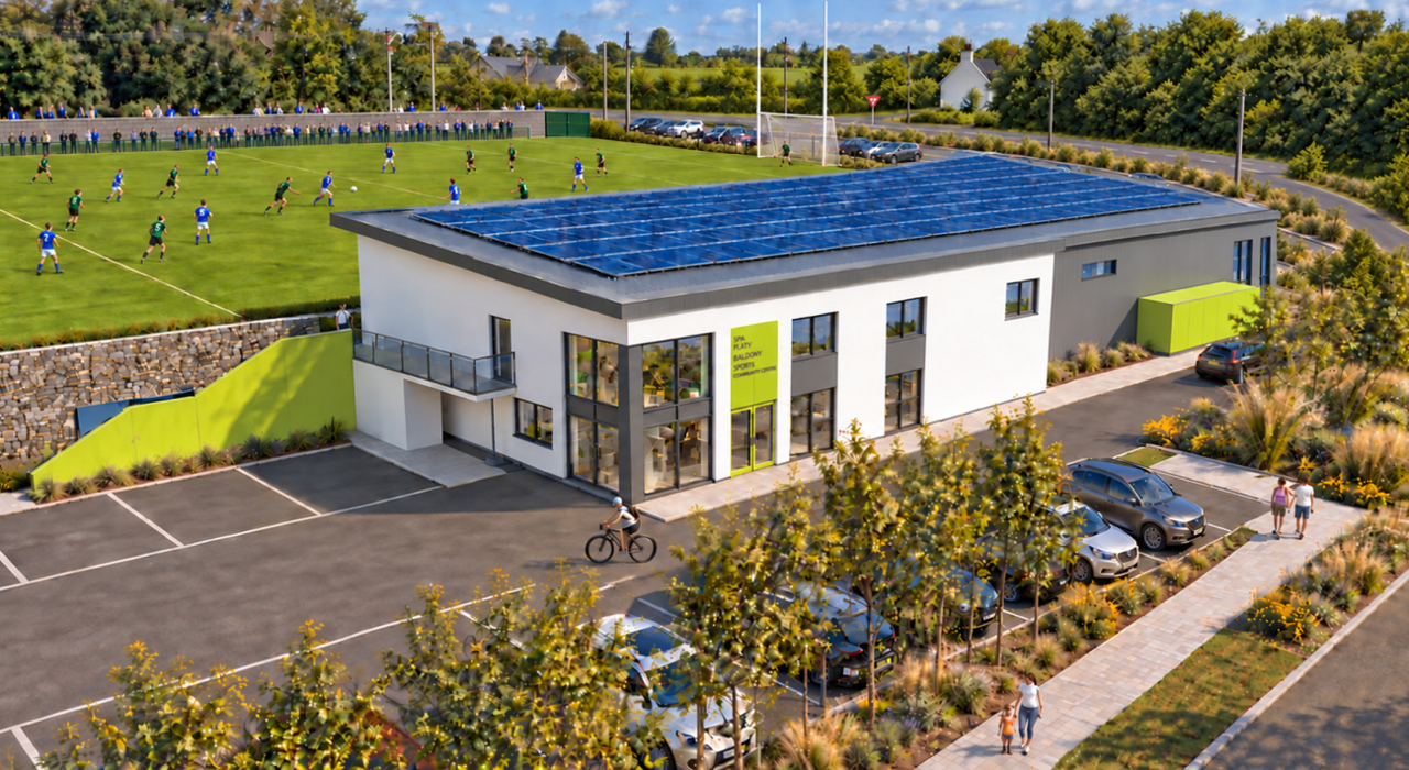 A modern athletic facility with a gym and sports courts, featuring solar panels on the roof, parking lot with cars, and a soccer field with players, surrounded by trees and greenery.