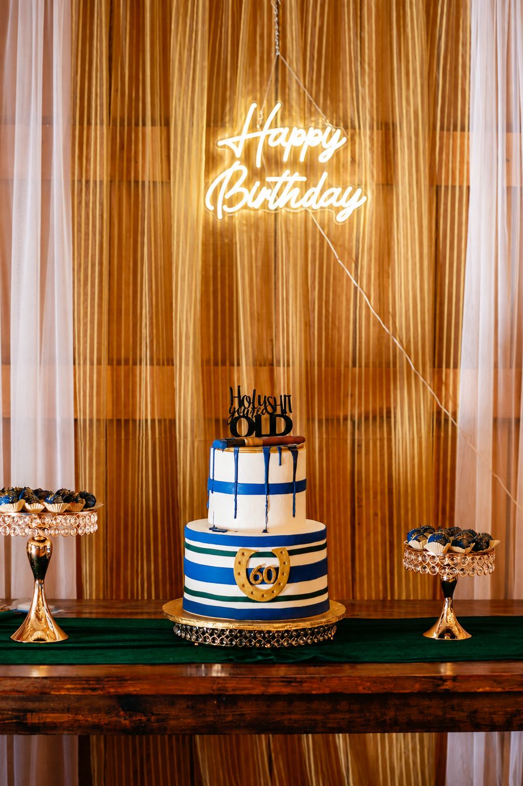 60th birthday cake display with gold dessert stands and navy, emerald and gold details.