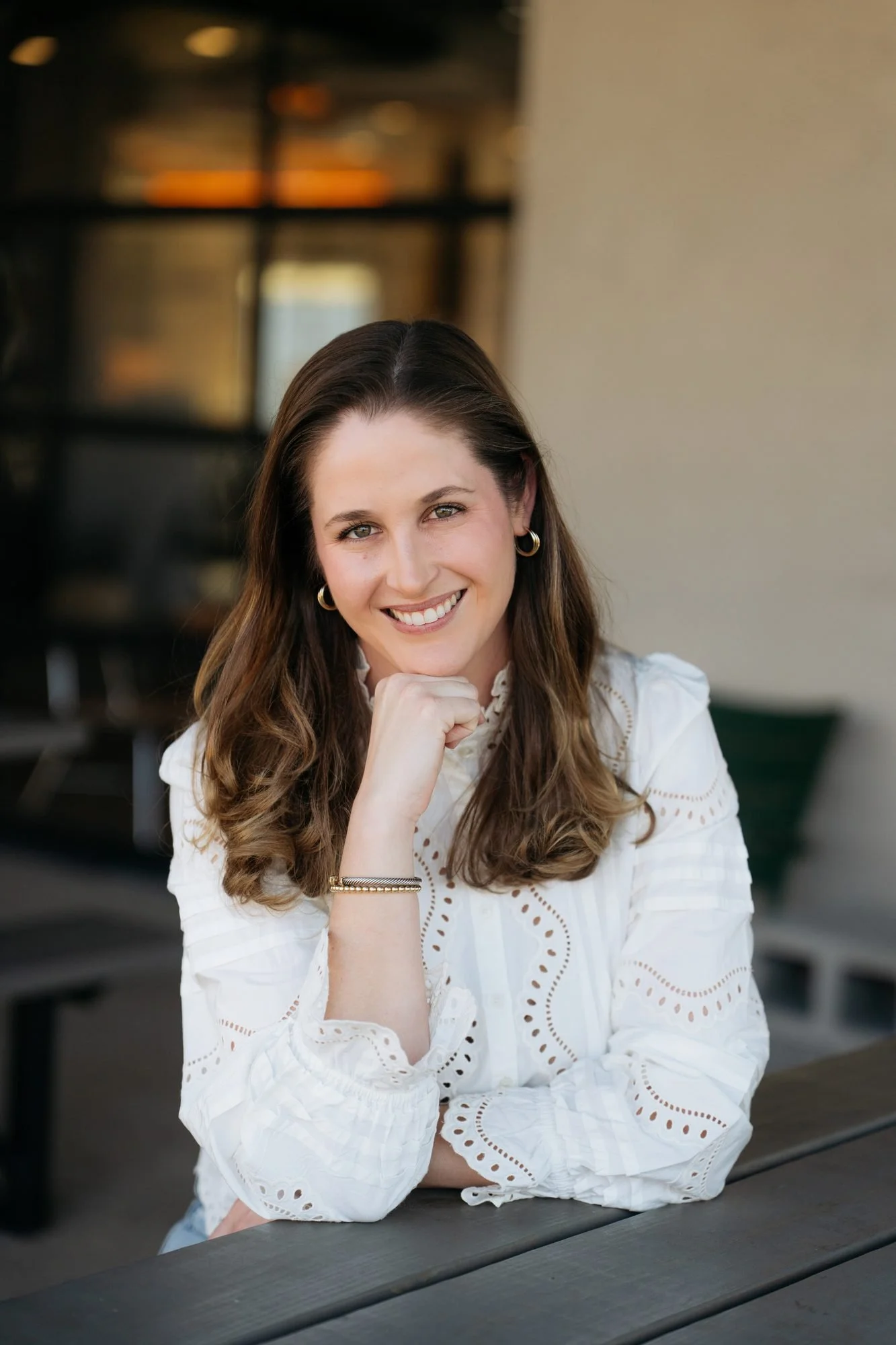 Sidney, founder of Asset By Design, smiling at an outdoor table