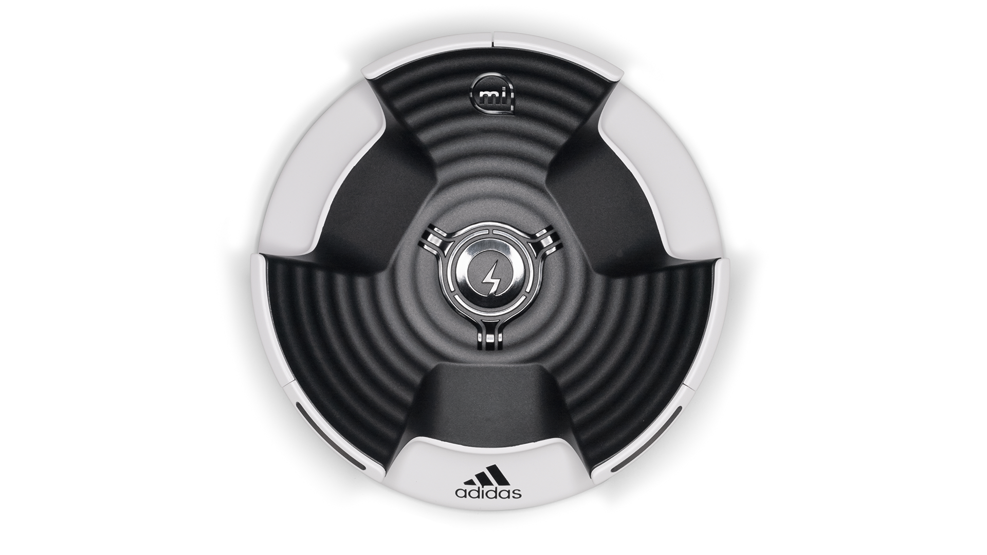 A circular black and white fitness device with a central lightning bolt symbol, the brand logo Adidas at the bottom, and the letters "mi" top-center, with a sleek modern design.