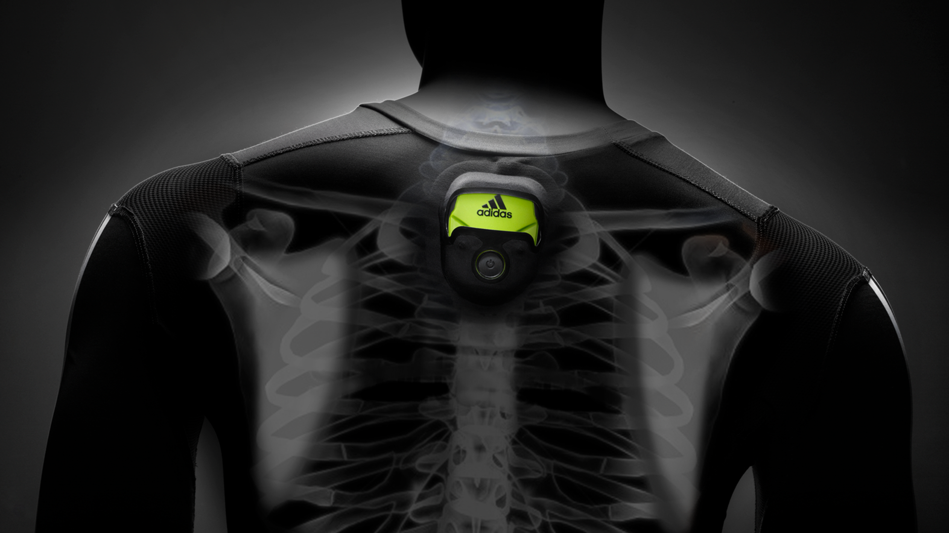 A person wearing a black sports shirt with a fitness tracker or heart rate monitor on their back, with an X-ray style overlay revealing their ribcage and spine.