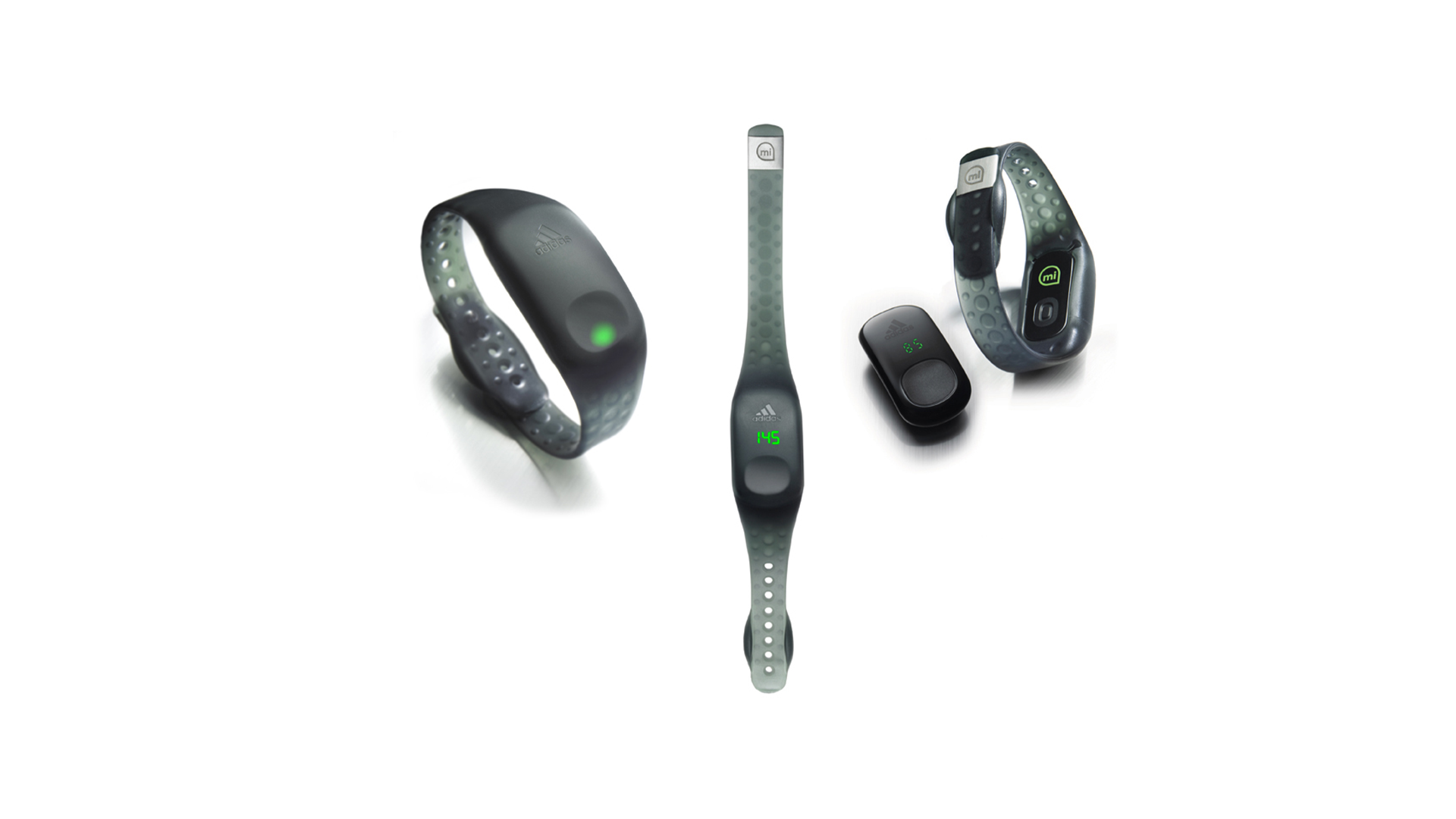 Multiple fitness trackers and heart rate monitors laid out on a white surface.