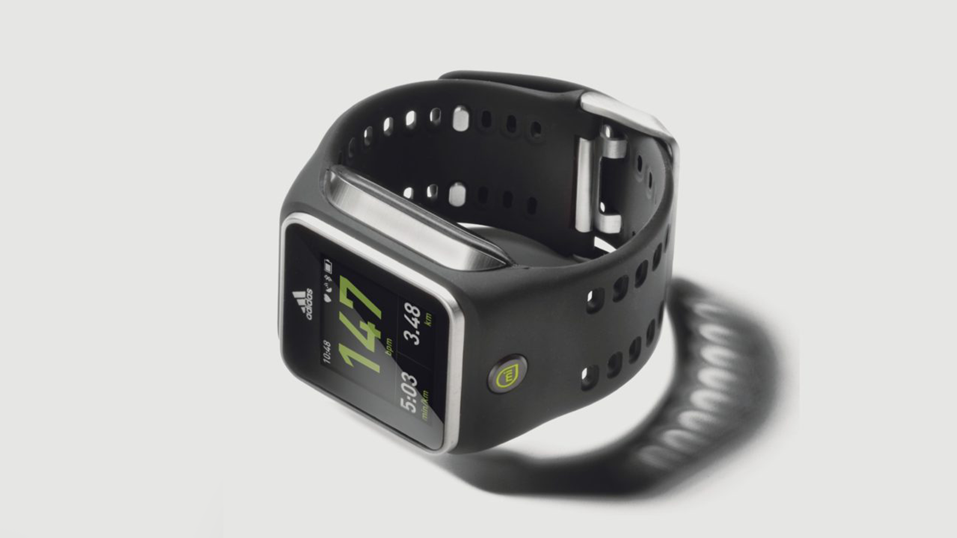 A black adidas digital sports watch with a rectangular face showing time, distance, and pace, connected to a coiled black band designed for fitness tracking.