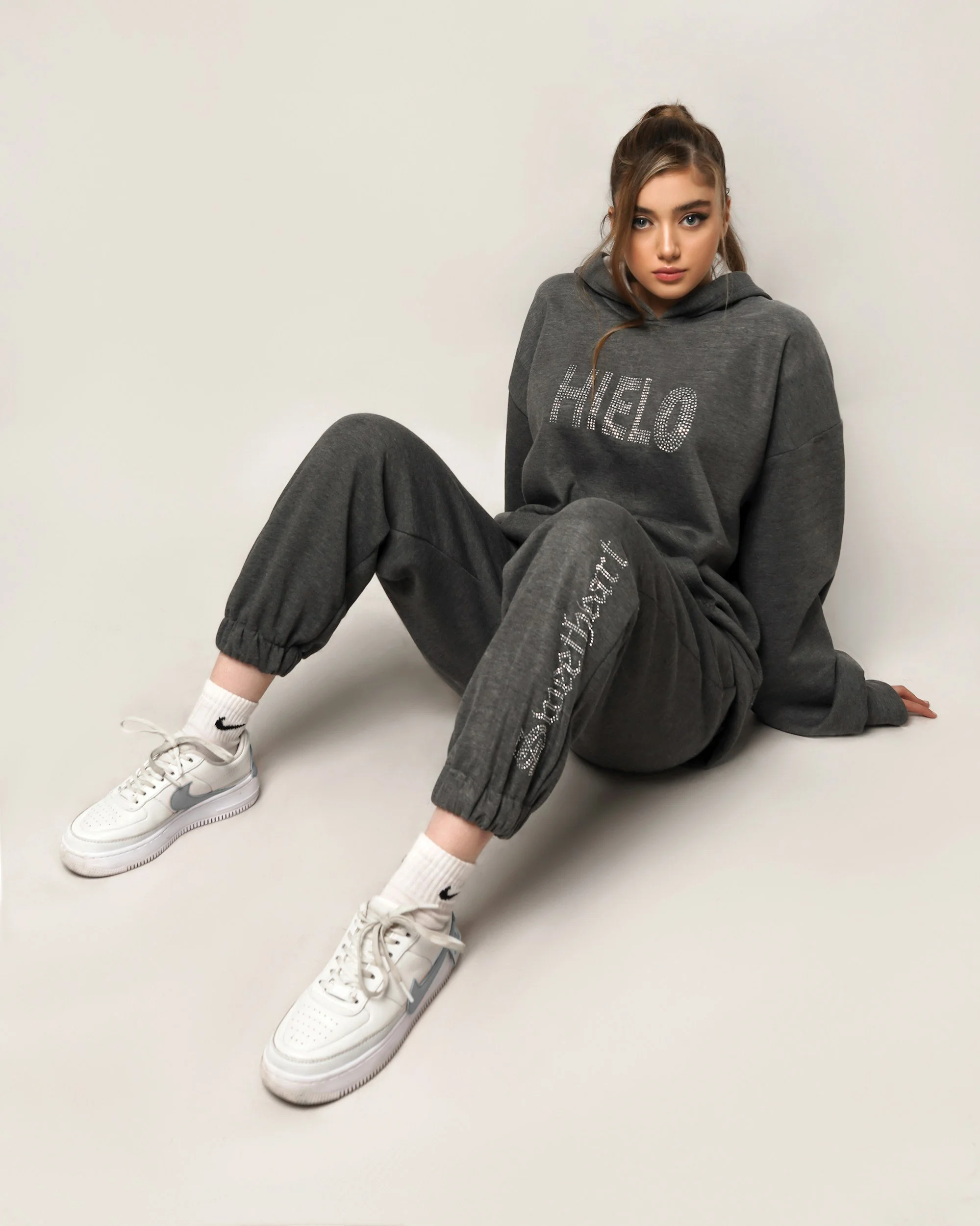 Woman in a grey hoodie and black pants