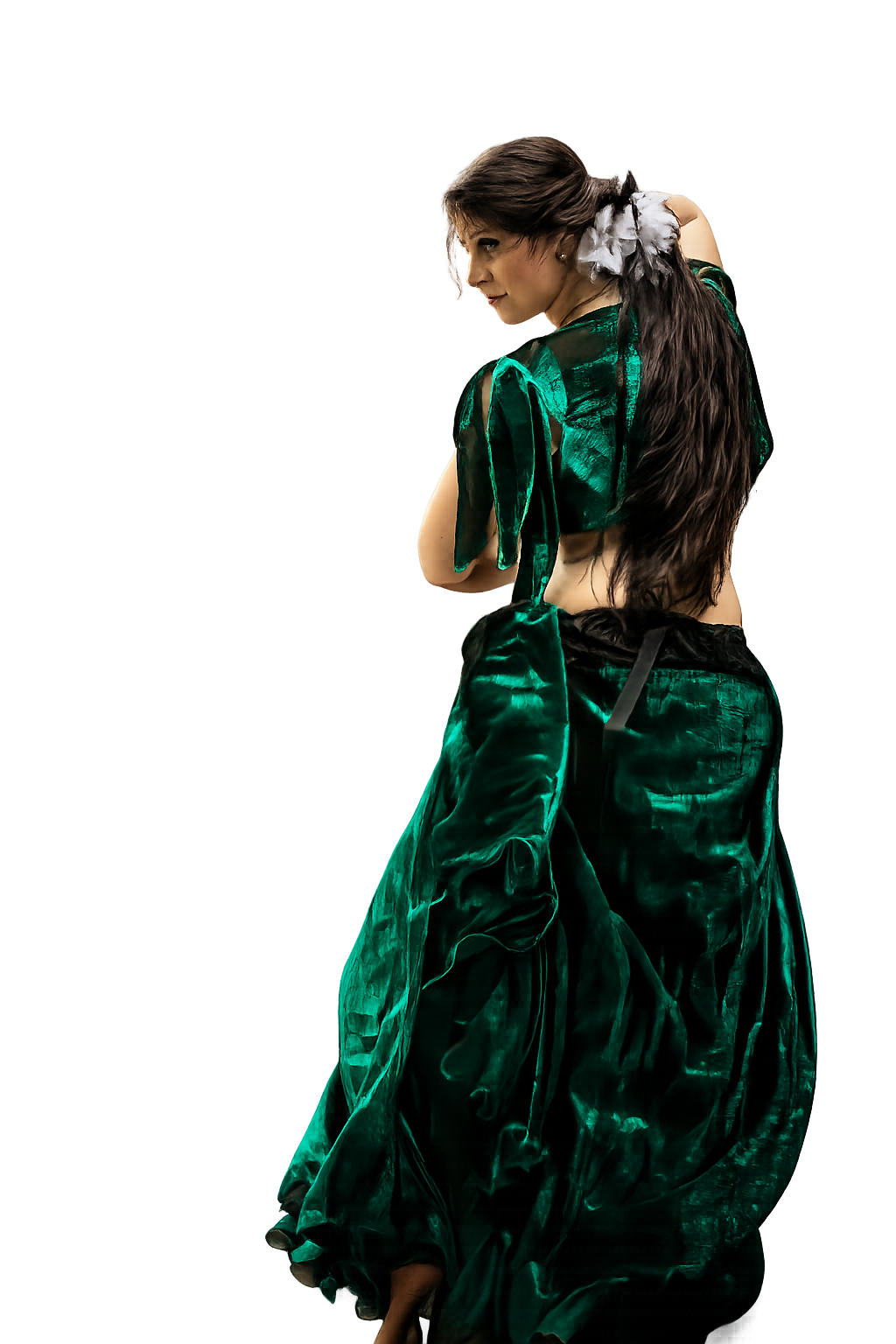 A young woman with dark brown hair styled in loose waves, wearing a green satin two-piece outfit with a crop top and oversized pants, posed against a black background.