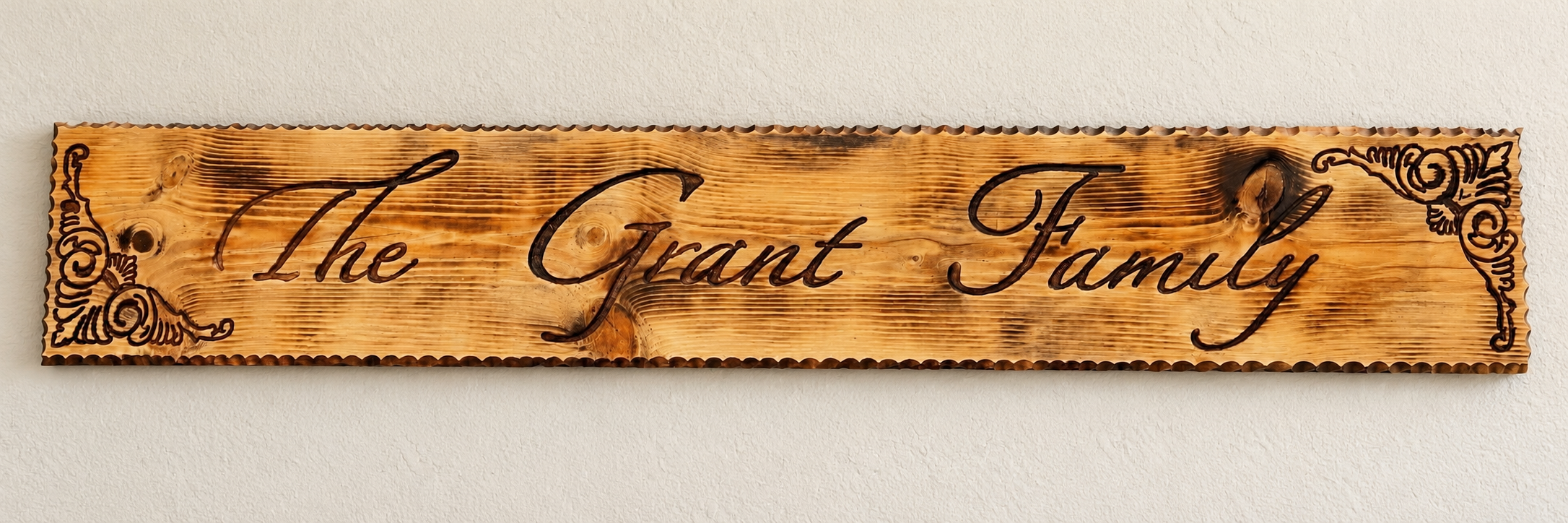 Personalized wooden sign reading The Grant Family, with decorative corners and a rustic wood finish.