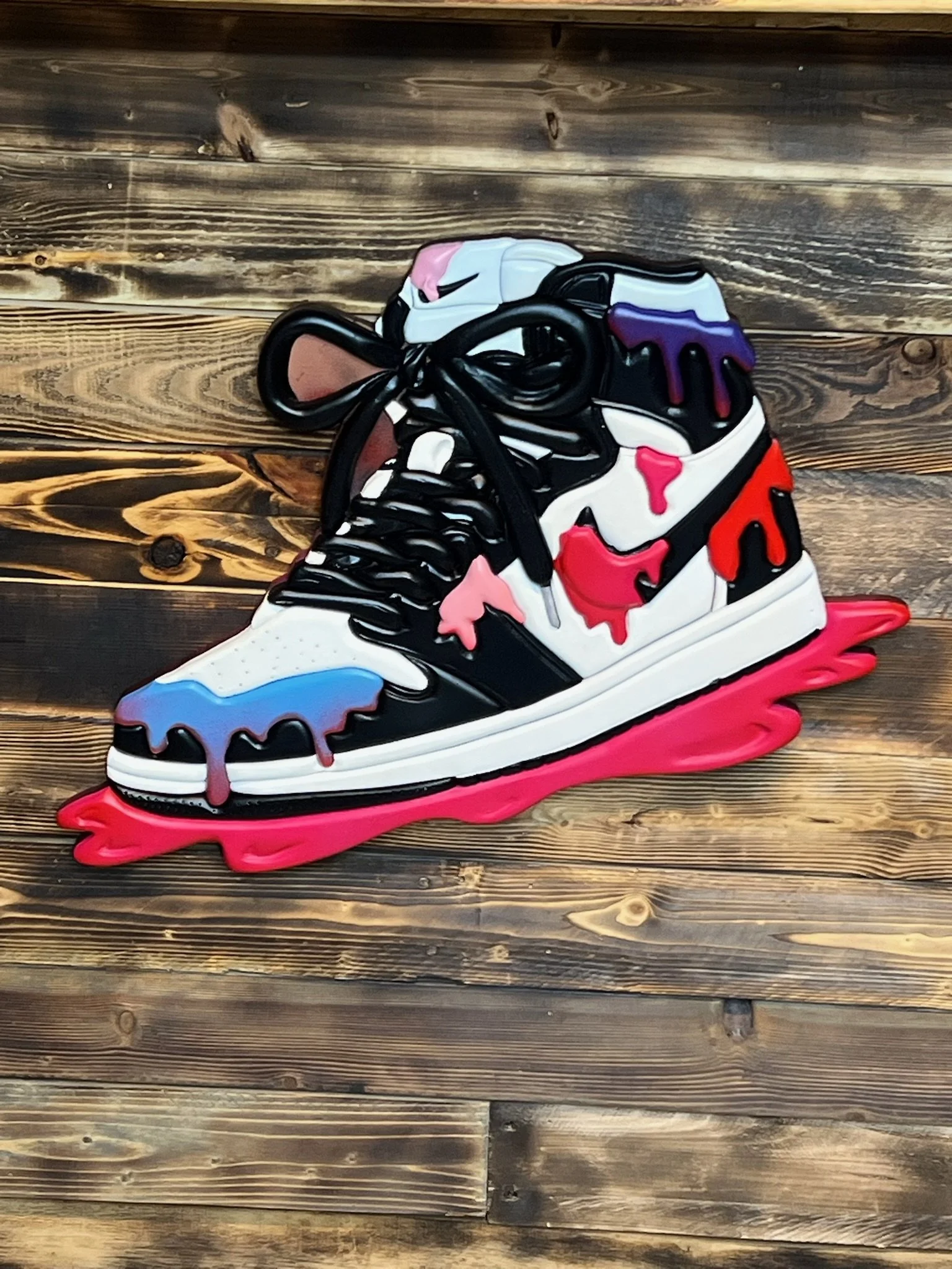 Handcrafted sneaker-shaped wooden wall art with bold pink, red, blue, purple, black, and white dimensional details.