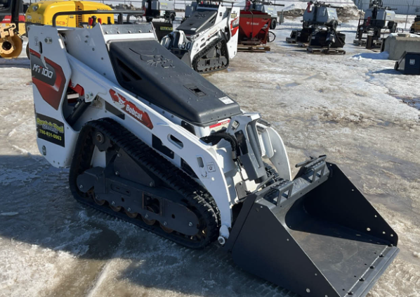 Bobcat Mini Track Loader in a snowy lot with other construction equipment
