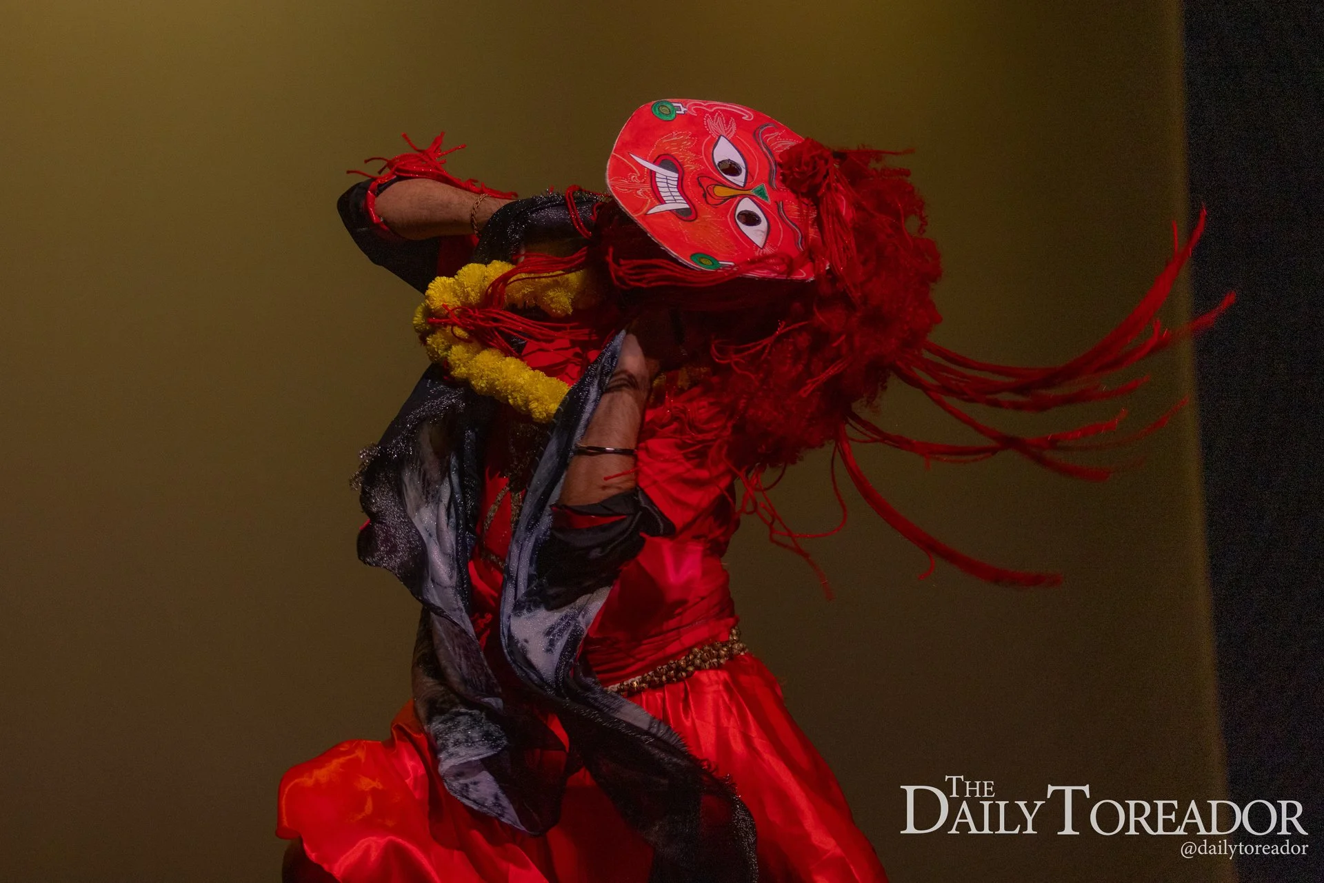 Performer in traditional Chinese costume and mask during a cultural dance or performance.