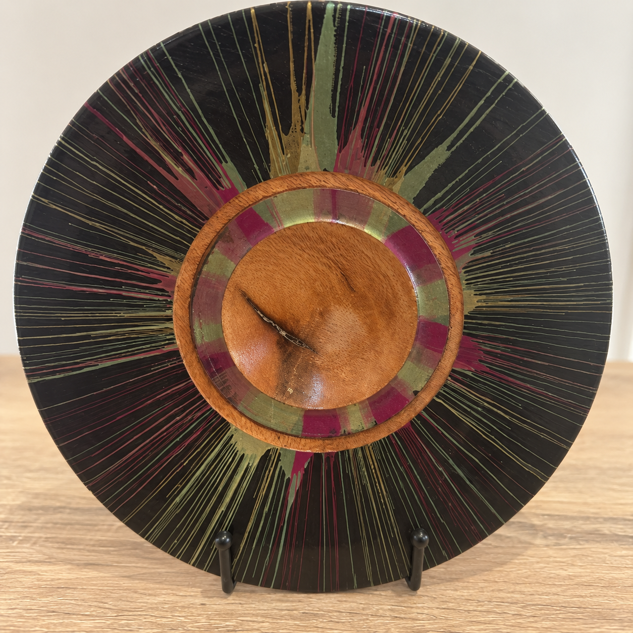 Angled view of hand-turned Silky Oak centrifugal decorative plate with high-gloss finish and stand