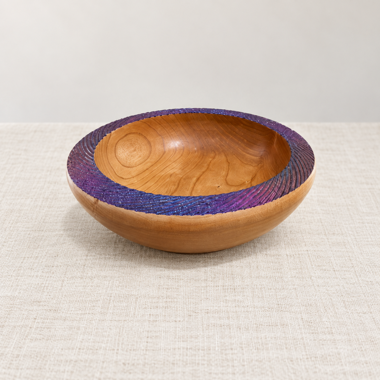 Hand-turned Cherry wooden bowl with a textured purple-blue colour-shifting rim