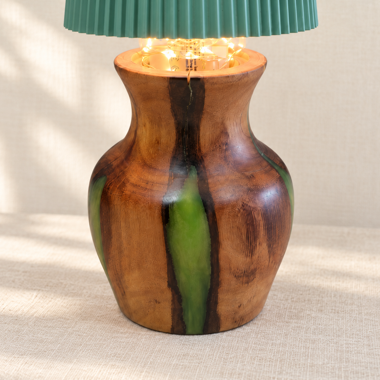 Close-up of the lamp’s hand-turned Australian hardwood base, natural grain and emerald green resin.