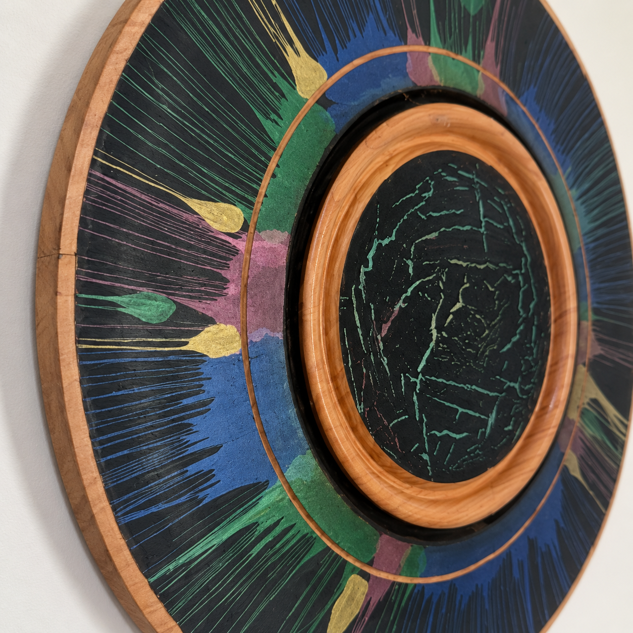 Detail of turned Silky Oak wall art showing the timber ring and colourful radial paint design