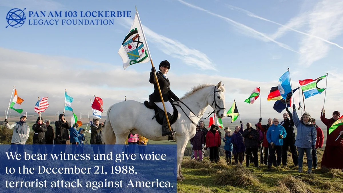 Rider on a white horse leads a flag-bearing remembrance gathering for the Pan Am Flight 103 Lockerbie victims.