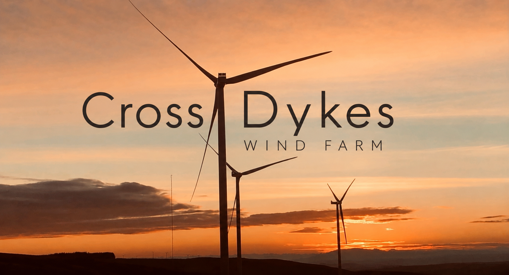 Crossdykes Wind Farm wind turbines silhouetted against an orange sunset