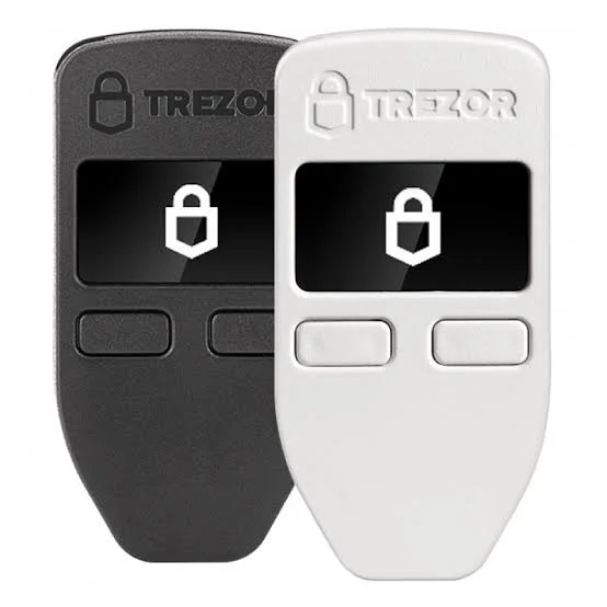 Two remote controls, one black and one white, featuring a digital display with a lock icon and the brand name Trezor.