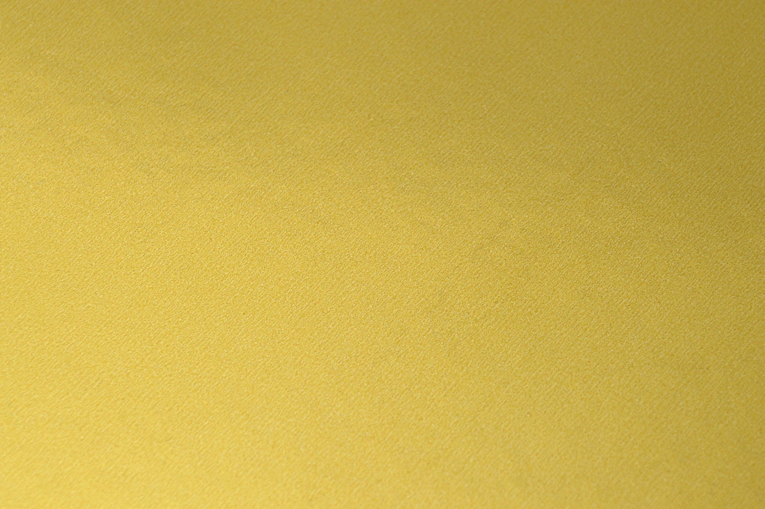 A close-up view of a yellow textured background or surface.