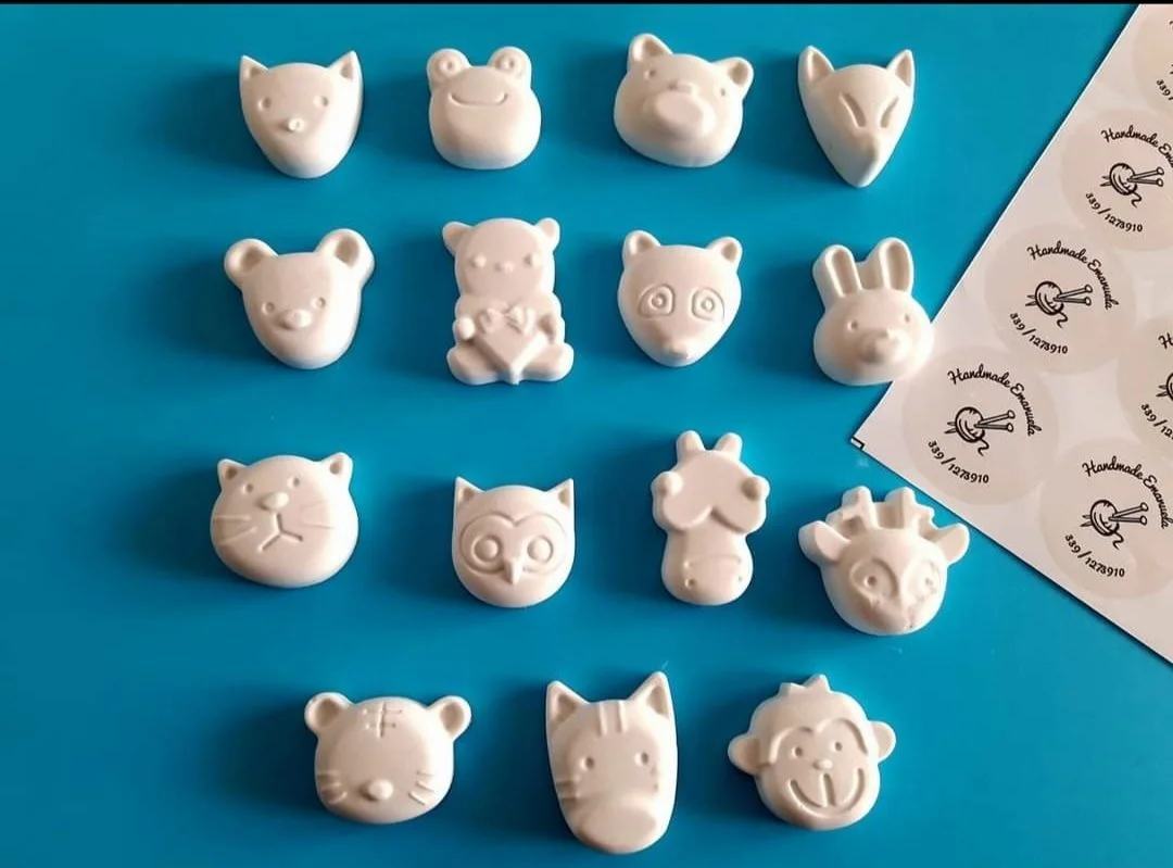 Quindici gessetti bianchi a forma di animaletti, tra gatto, rana, orso, coniglio, gufo e scimmia, su fondo azzurro
