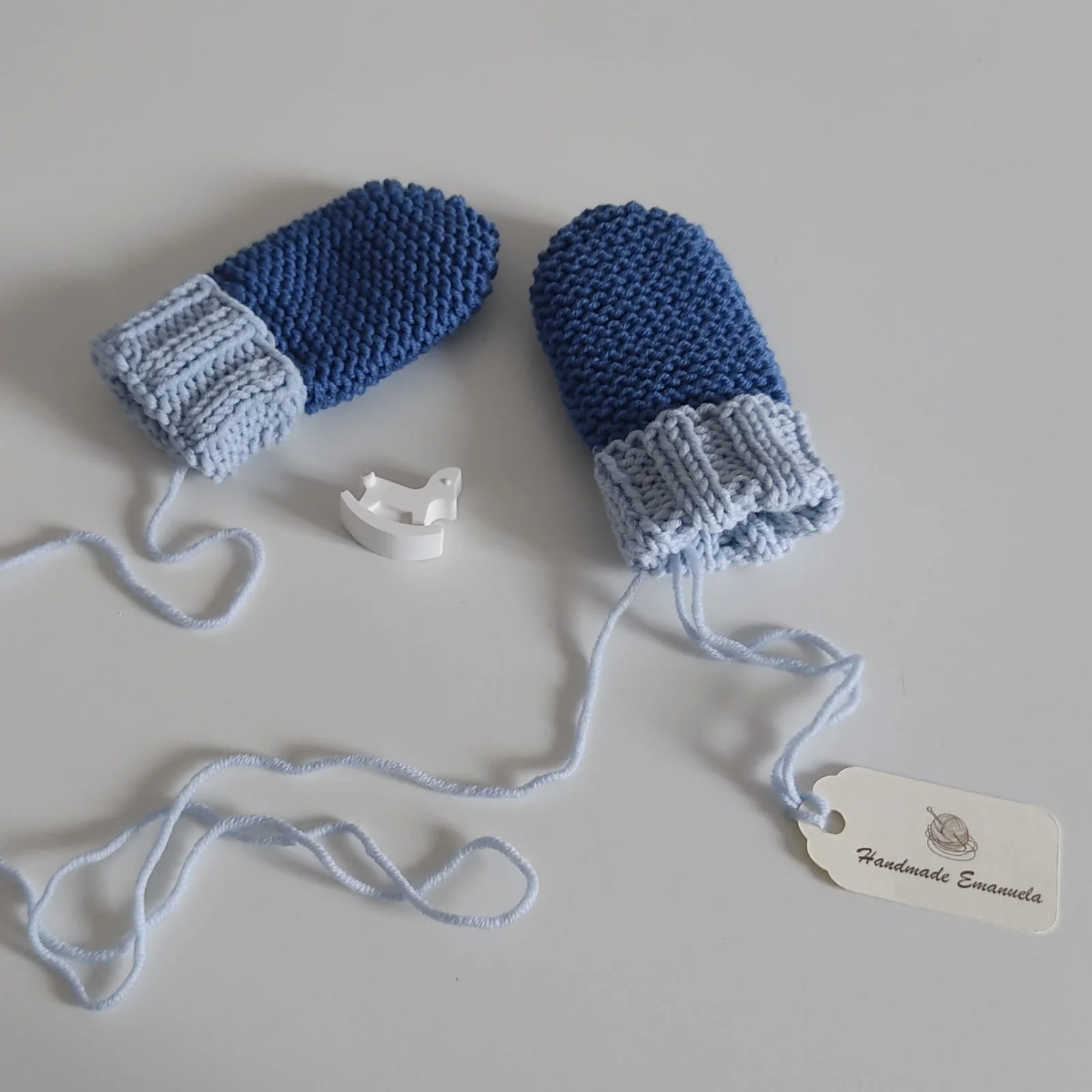 Paio di moffole in maglia blu con polsino a coste azzurro e laccetti lunghi, con cartellino