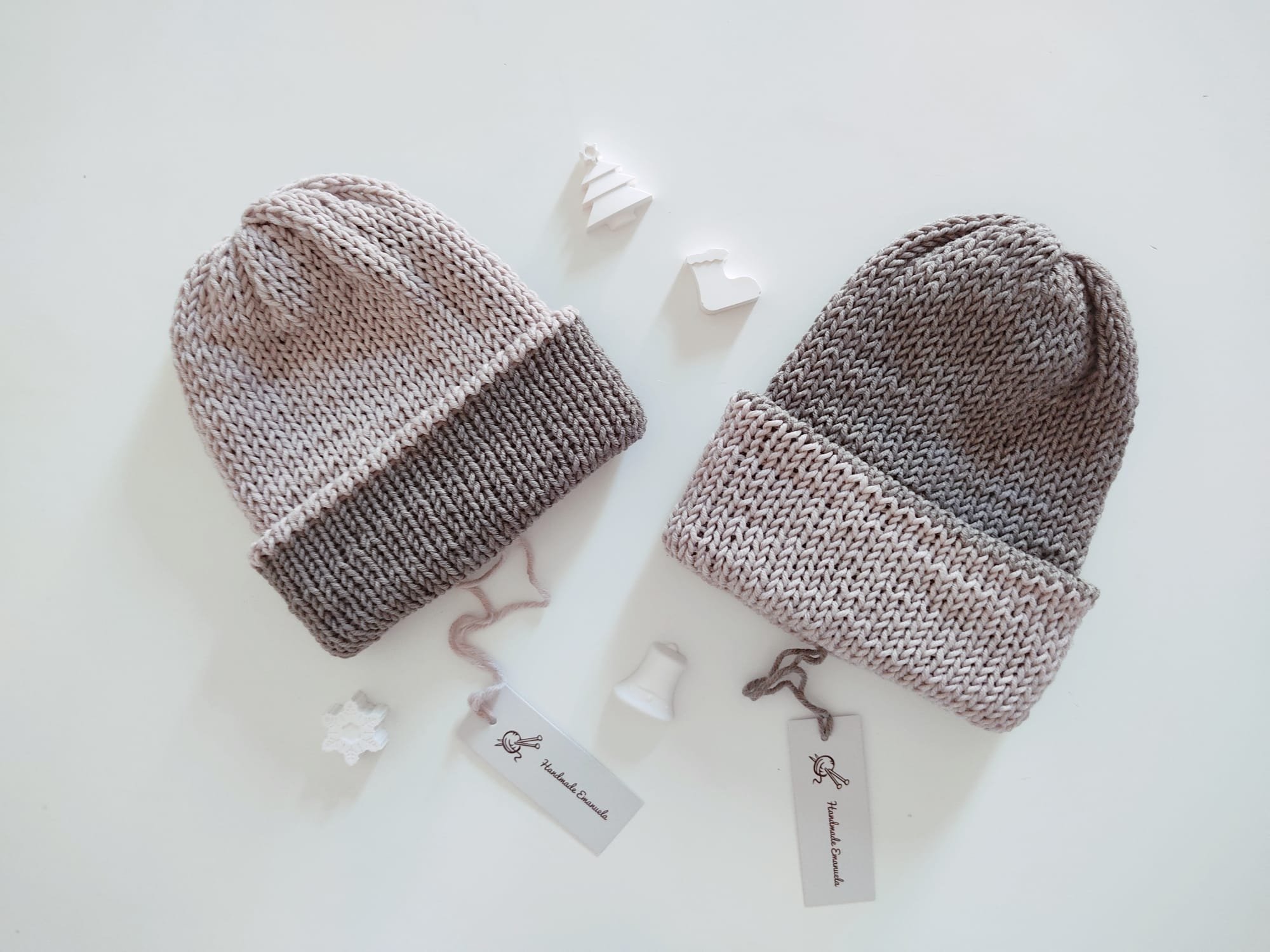 Due cappelli in maglia bicolore grigio chiaro e grigio scuro con risvolto, uno con i colori invertiti, con cartellini
