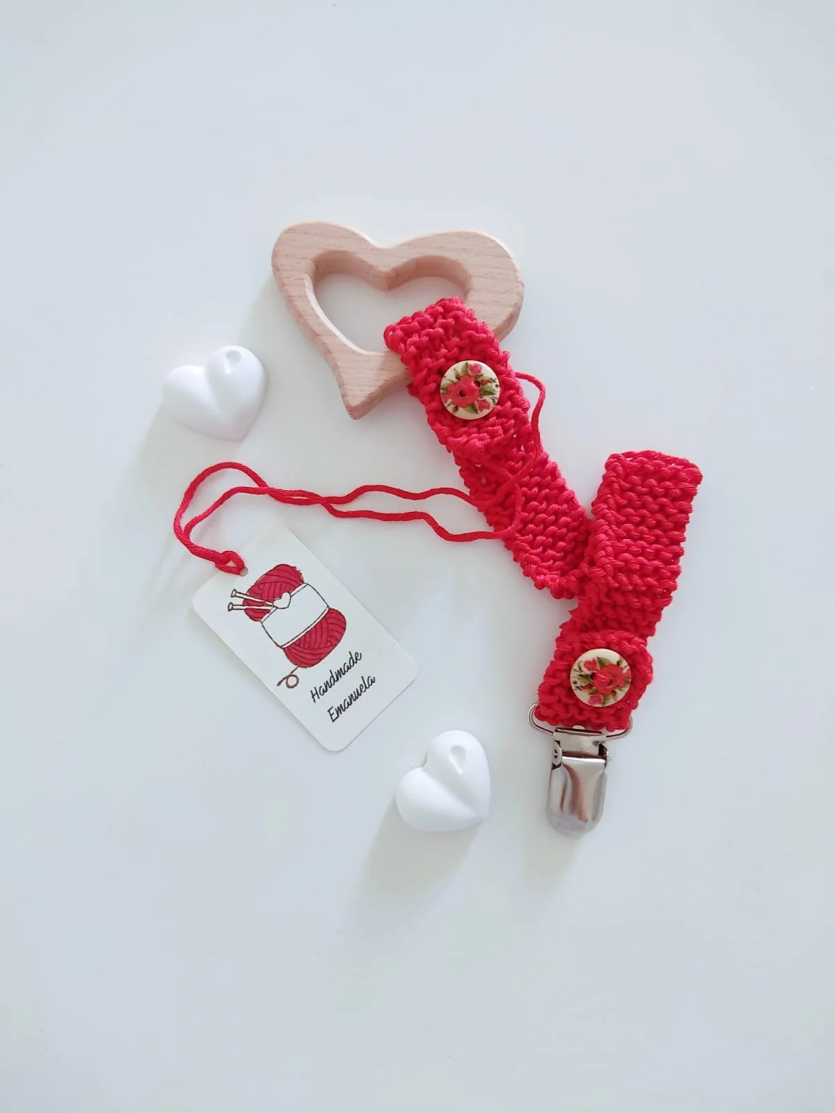 Portaciuccio in maglia rossa con giochino in legno a forma di cuore e bottoni in legno decorati con fiori, con cartellino