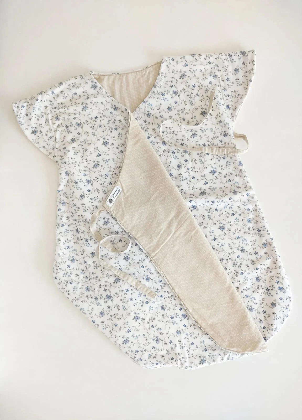 Sacco nanna a kimono in cotone bianco a fiorellini azzurri, con interno beige, fiocchi laterali ed etichetta