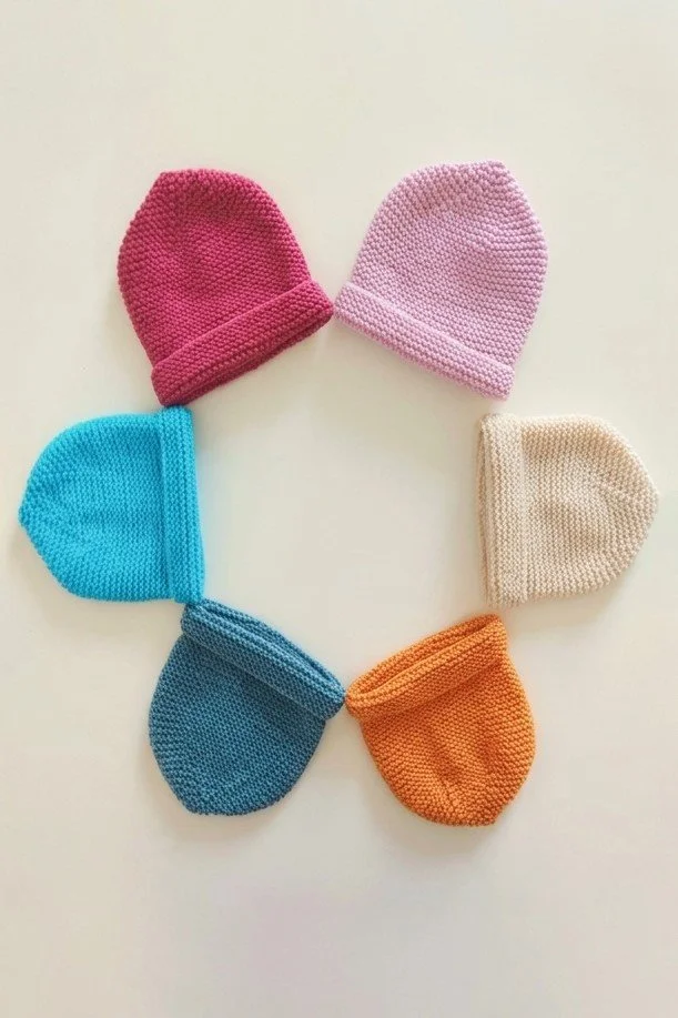 Sei cappelli in maglia a tinta unita con risvolto, in fucsia, rosa, turchese, crema, blu petrolio e arancione